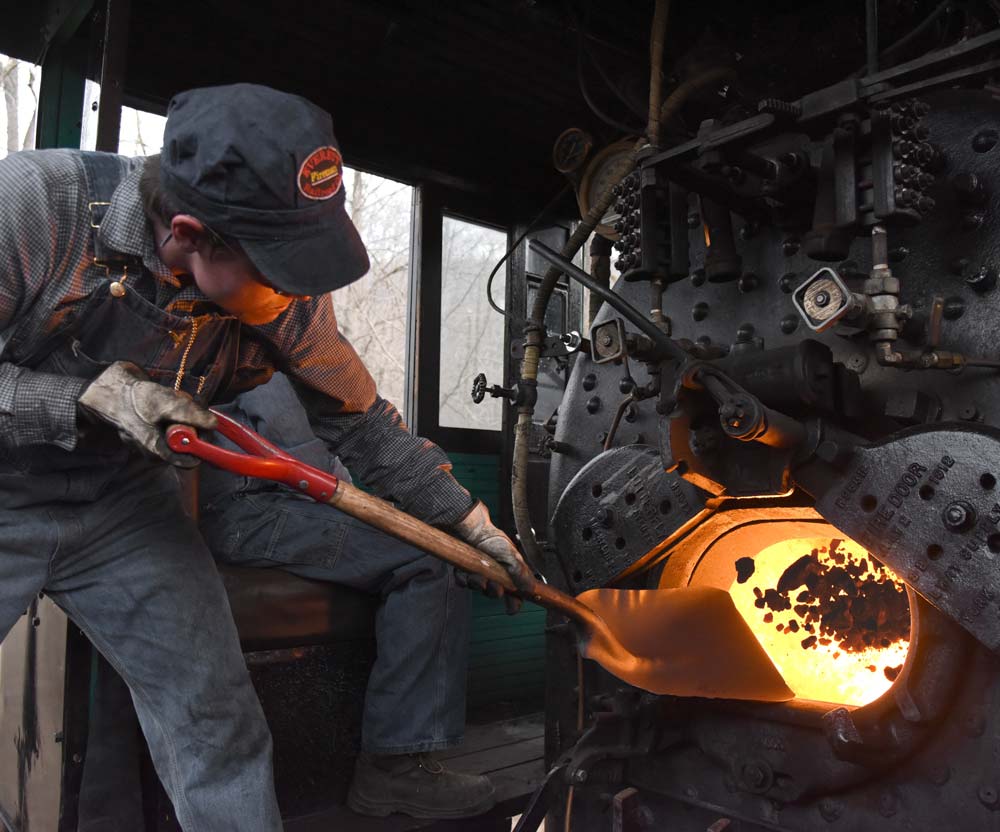 EVRR fireman Stephen Lane shovels a scoop of coal into the firebox of No. 11 during a trip in December 2015. Photo by, and used courtesy of, Oren B. Helbok.