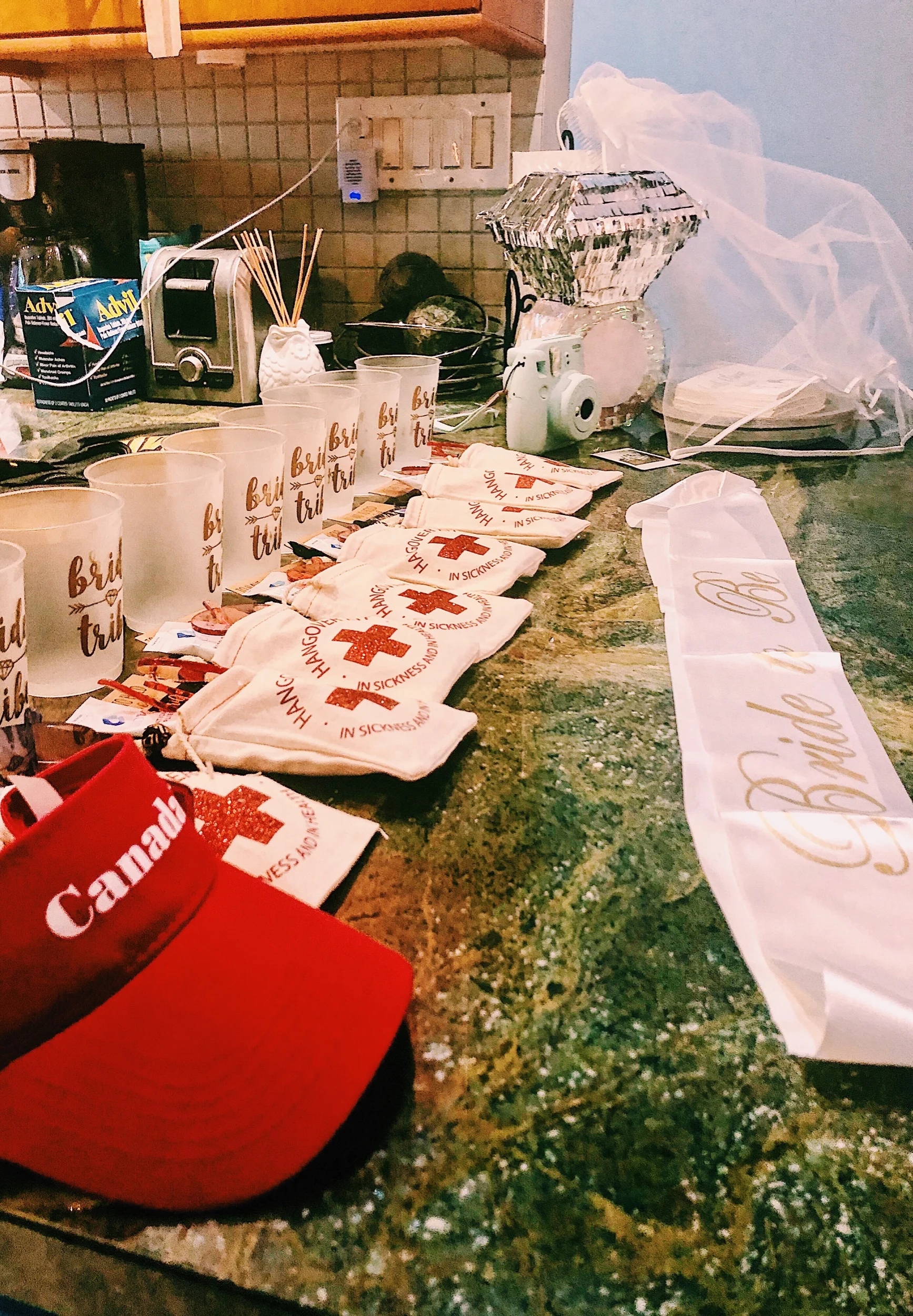 A Canada visor, “Bride Tribe” cups, a ring piñata, a white “Bride to Be” sash, and of course, hangover kits 😂😜