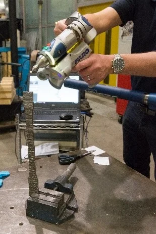 Calibrating a 3D-printed stainless steel coupon, in preparation for a tensile test.