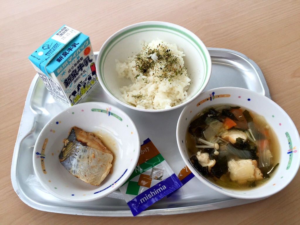 Grilled herbed fish, rice with seaweed and sesame garnish, tofu and vegetable soup with a carton of milk.