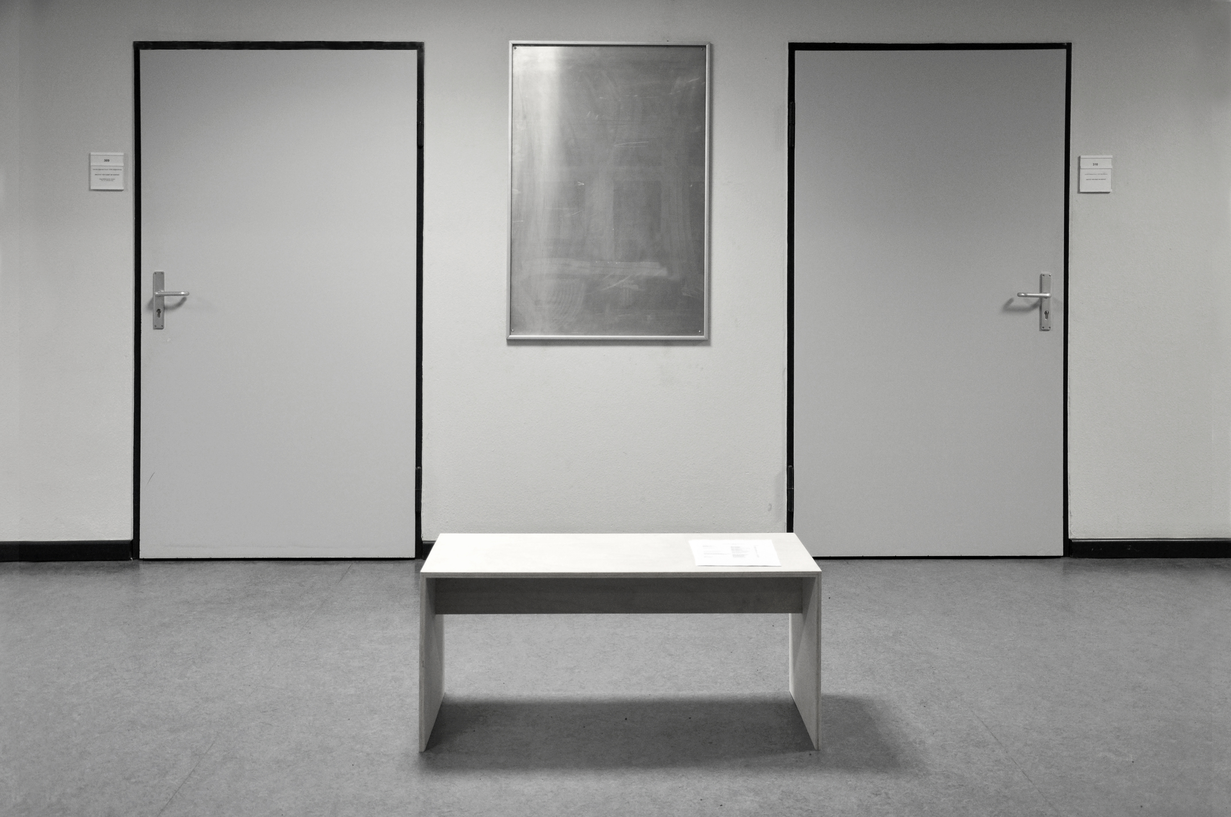 Display einer Verwaltung wooden bench, A4 cheets. 2013 Institute Art in Context, Berlin. The text of the infoboard about the administration and employees of the institute were removed and written on A4 sheets. The sheets were placed on a wooden bench opposite the infoboard. (more pictures)