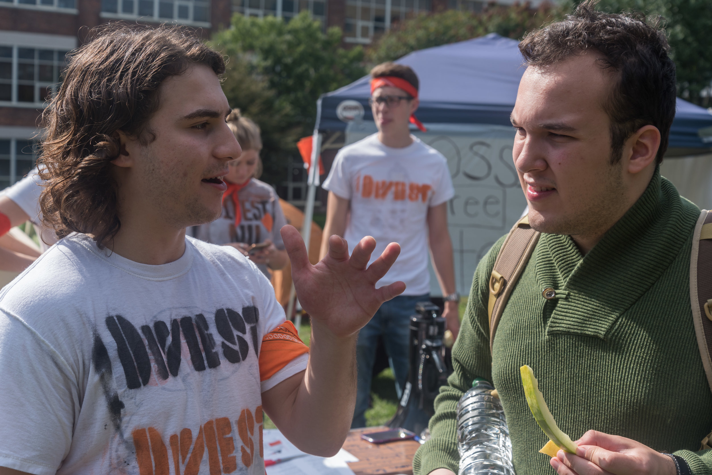  DivestNU member Charlie Cavallaro, left, talks to Northeastern sophomore Philip Wesley, right, about climate change and policy on Centennial Common on Monday, Oct. 3. 