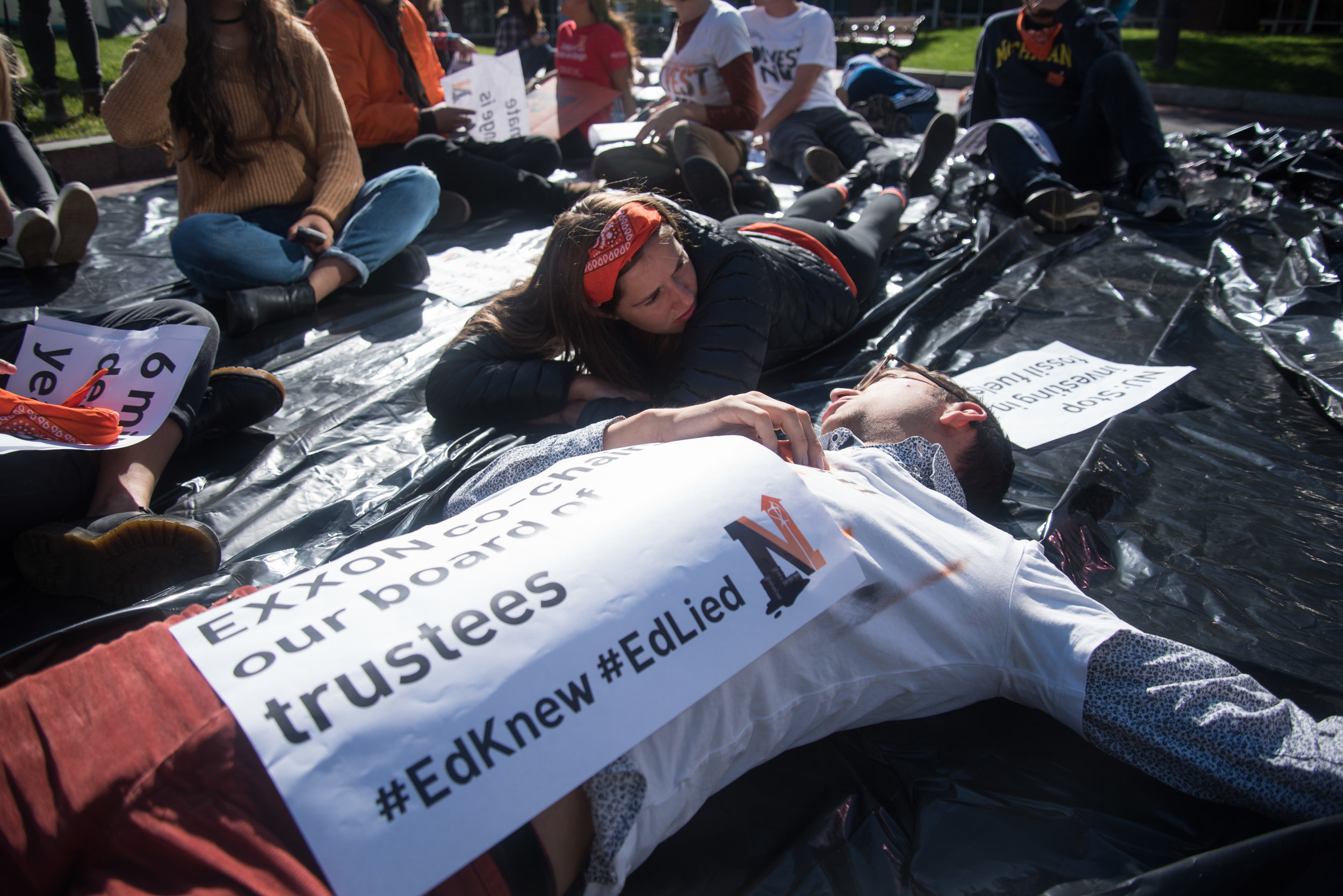  Left to right, DivestNU members Haley Havens and NIck Boyd pretend to die at Centennial Common on Saturday, Oct. 15. After camping in the common for 13 days, DivestNU staged an oil spill, symbolized by the black tarp, and die-in to protest Northeast