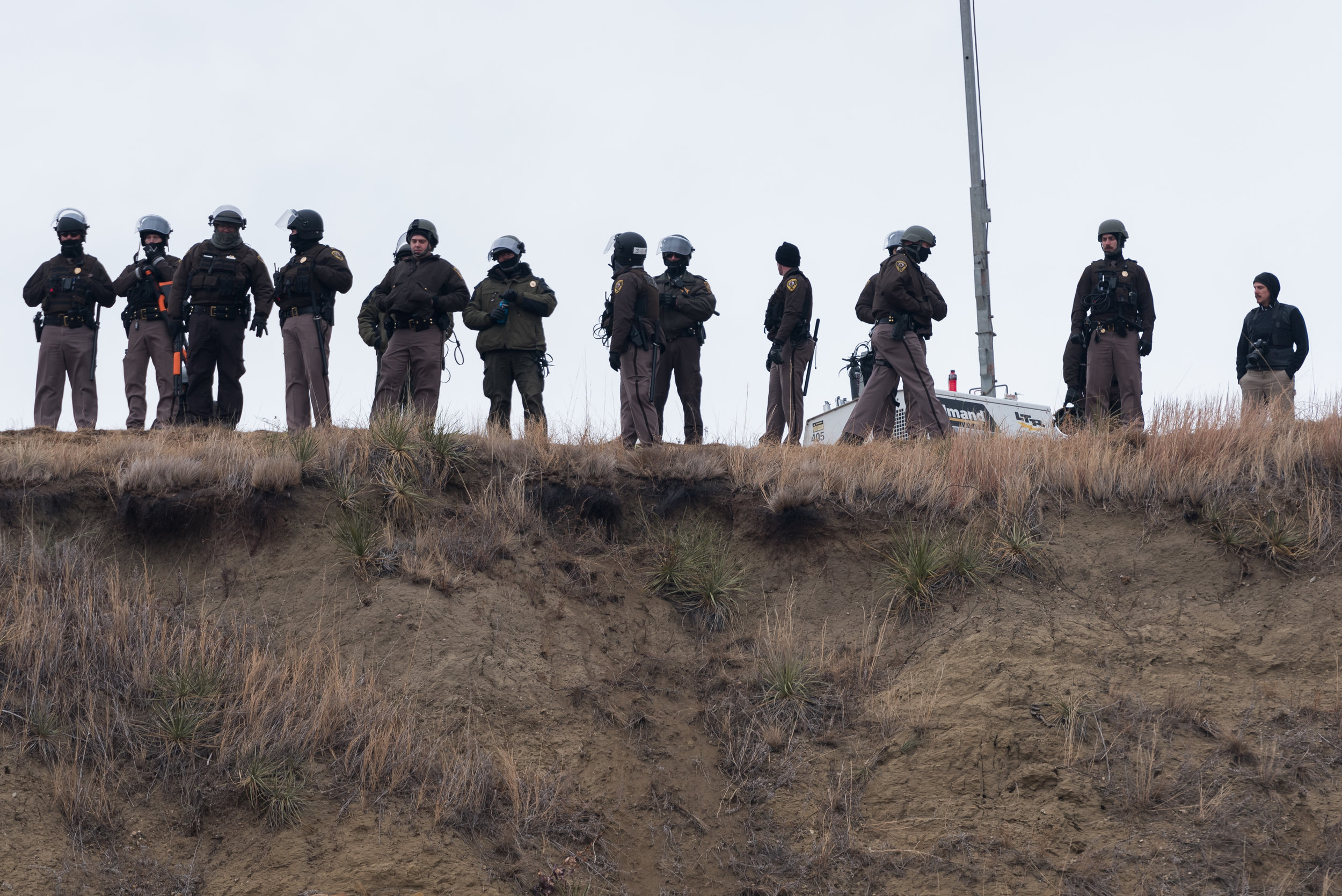  CANNON BALL, North Dakota — Morton County Sheriff’s Department officers and North Dakota state troopers on Turtle Island look down at water protectors on Thursday, Nov. 24. Although interactions with police had been violent at times, the demonstrati