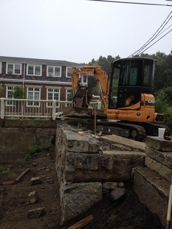 Excavator moving Granite into place