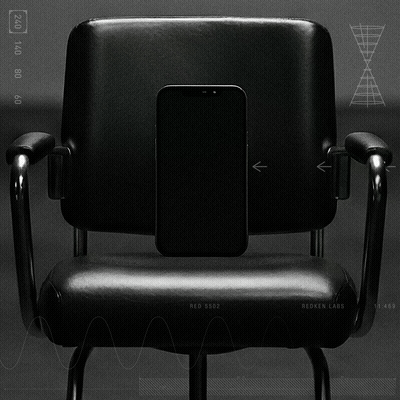 A black office chair with a smartphone placed in the middle of the backrest.