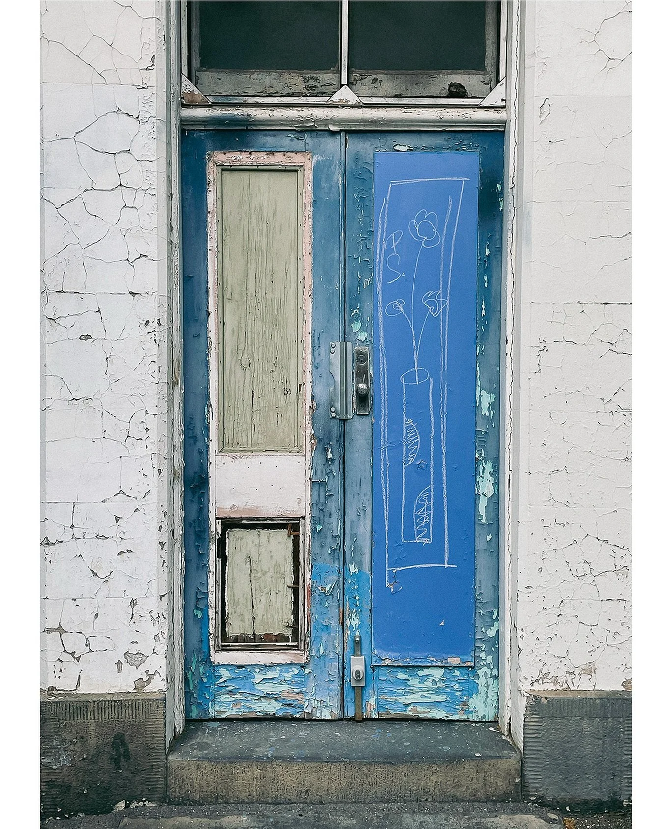 Layers of time, painted and repainted, peeling but still holding stories. This Carlton doorway carries a quiet poetry&mdash;hand-drawn flowers on chipped blue, fading into the cracks of memory.
From my &lsquo;Portraits of the Inner North&rsquo; exhib