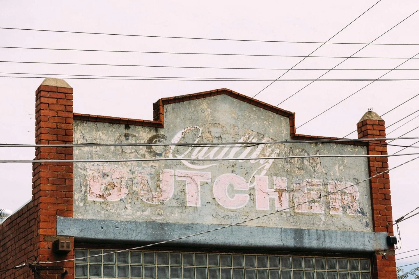 Layers of paint, type, and time &mdash; each one revealing a fragment of what came before.

This old Quality Butcher sign has outlasted its trade, its owner, and maybe even its meaning &mdash; yet it still holds the street together.

What&rsquo;s you