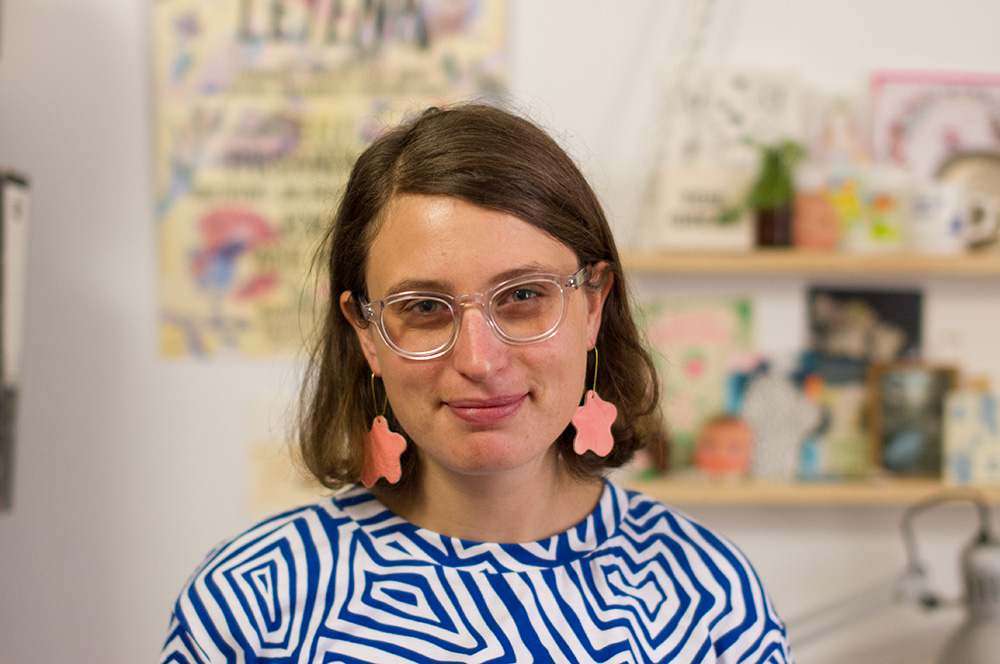 Esther Sandler in her studio, wearing gorgeous ceramic earrings she made.
