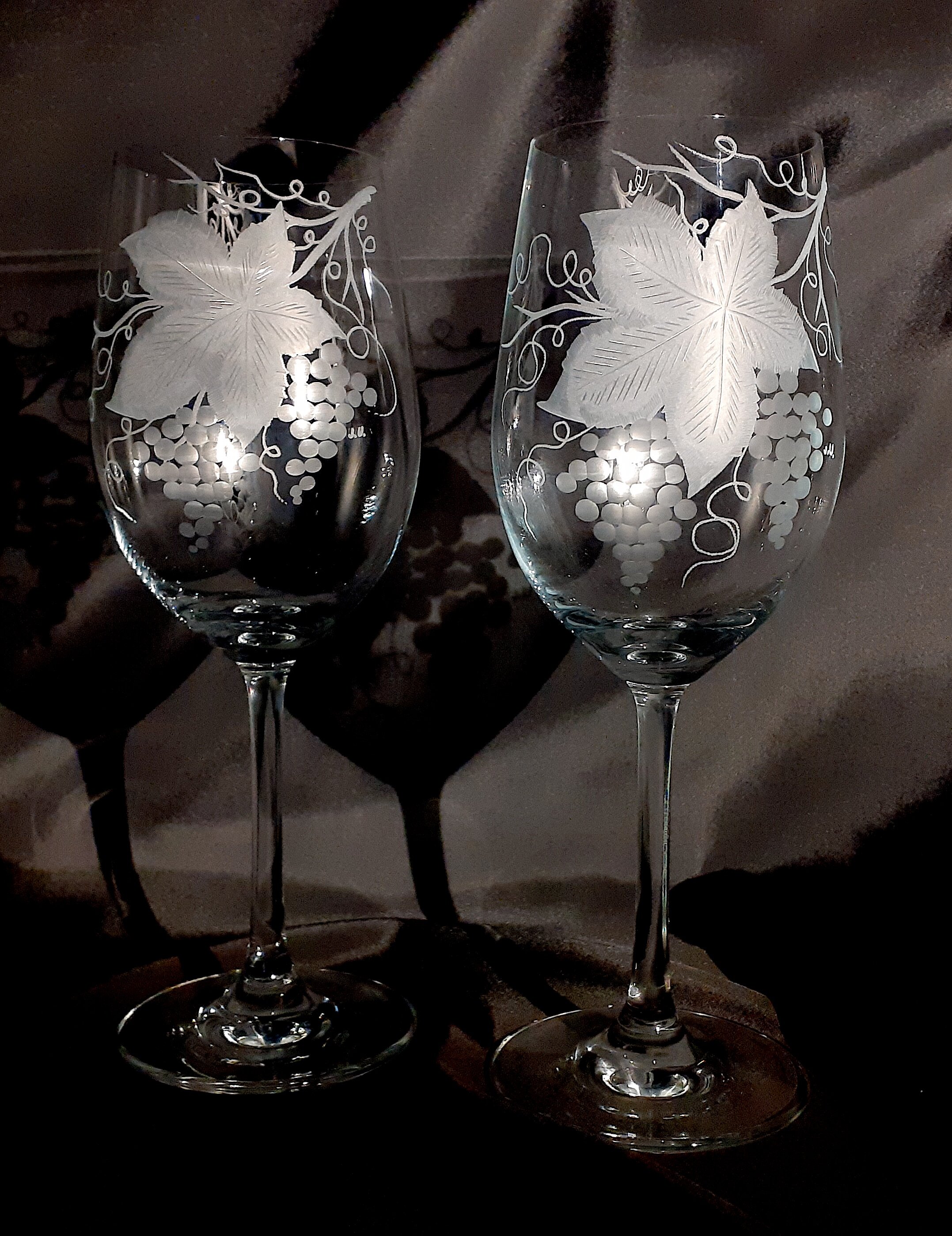 two wine glasses hand engraved with grape design