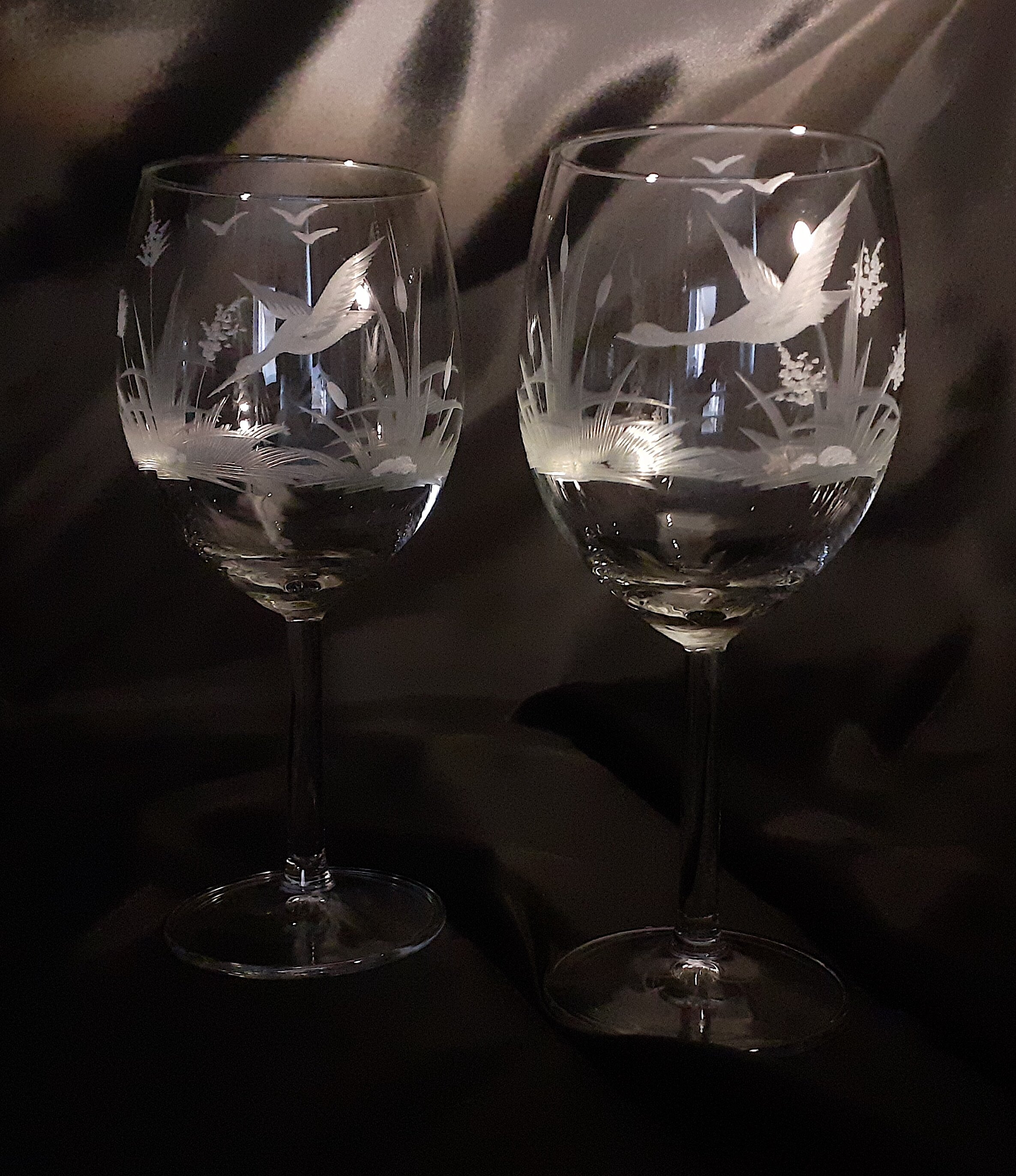 2 wine glasses hand engraved with different bird on each glass