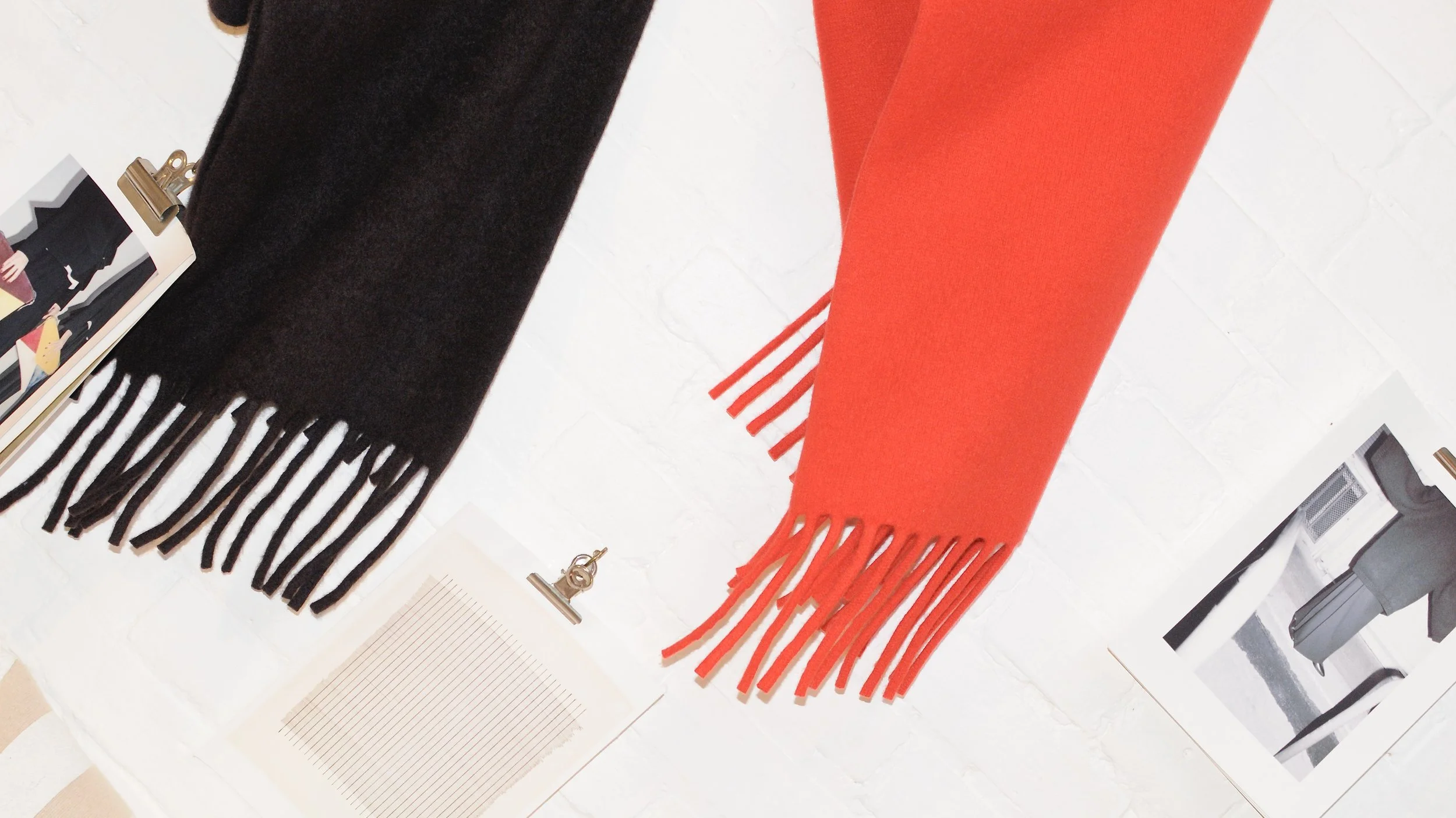 Black and red FRINGE scarves displayed on the SHEPHERD studio wall.