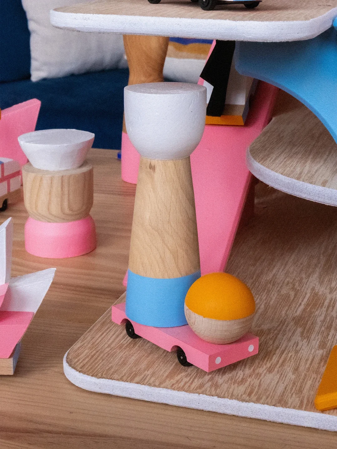 Objets en bois et en plastique de différentes formes et couleurs disposés sur une surface en bois.