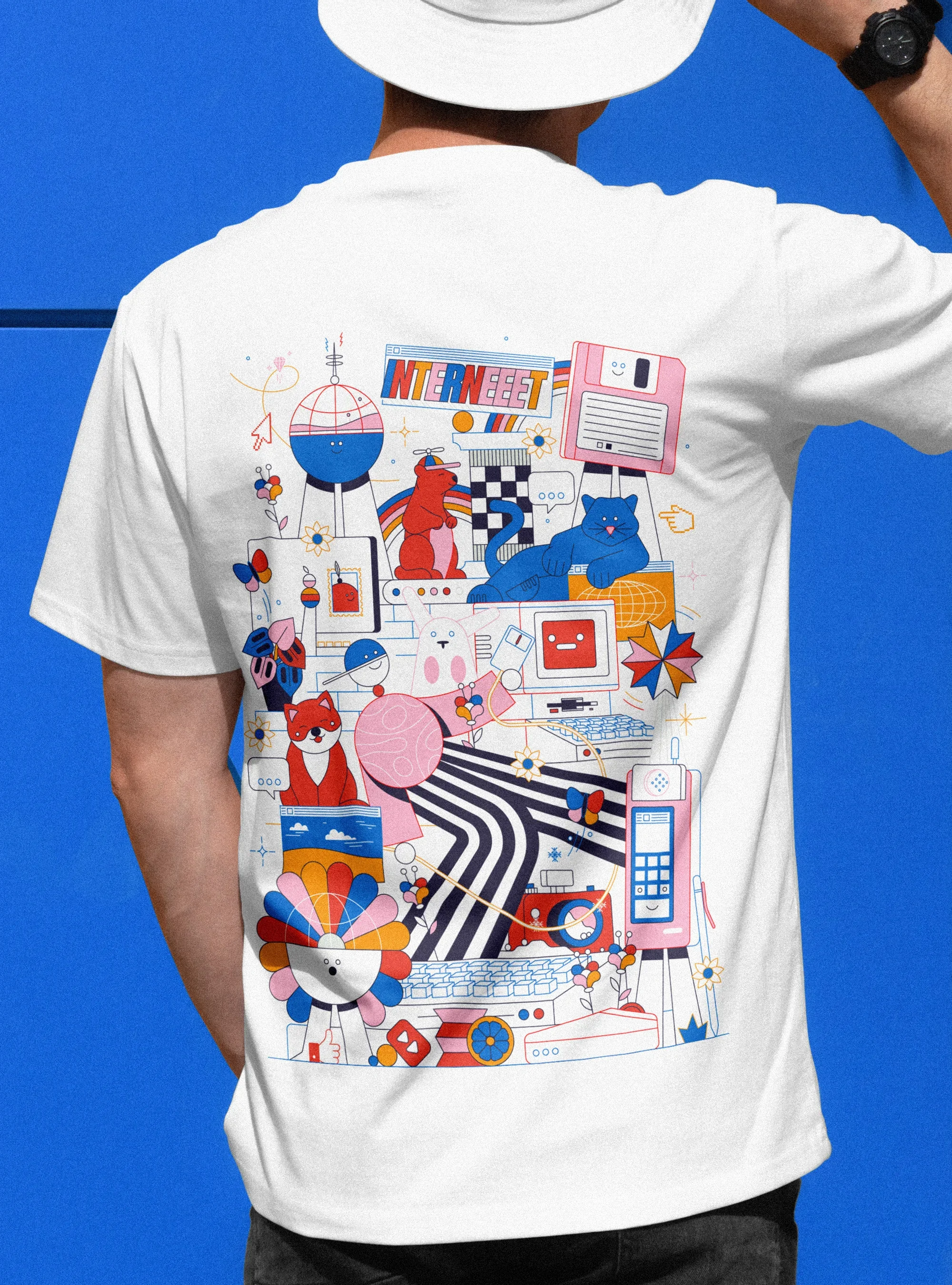 Personne portant un t-shirt blanc avec un design coloré représentant des éléments liés à Internet et aux technologies, tel qu'un ordinateur, une souris, un téléphone, un enregistreur, un chat, un laptop, et diverses icônes et illustrations abstraites, avec un fond bleu.
