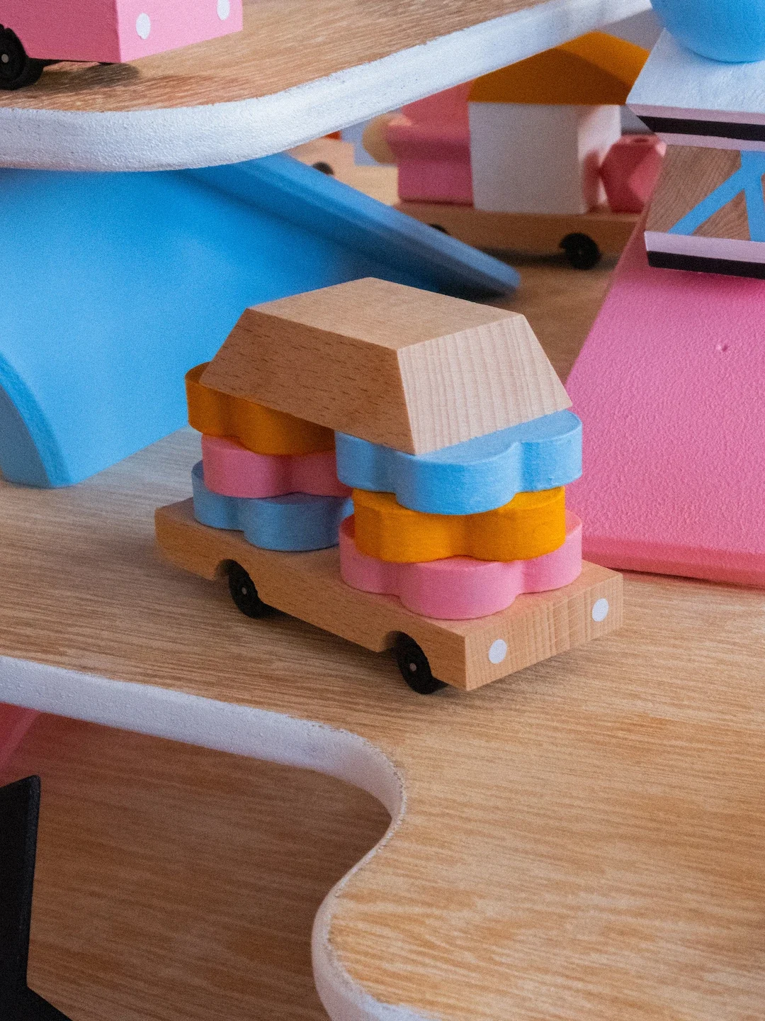 Un jouet en bois représentant une petite palette de glaces et un gâteau en bois décoratif de différentes couleurs pastel.