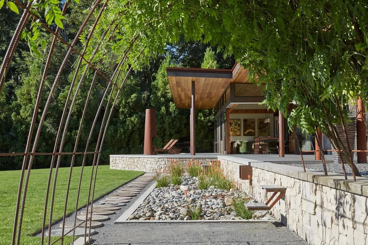 Capturing the character of our #IslandEquestrianCottage through the rebar arbor beautifully&nbsp;frames this space beyond the wisteria vines. From the weathered steel to the warm limestone walls, the mixture of materiality at our #MCTarchIslandEquest