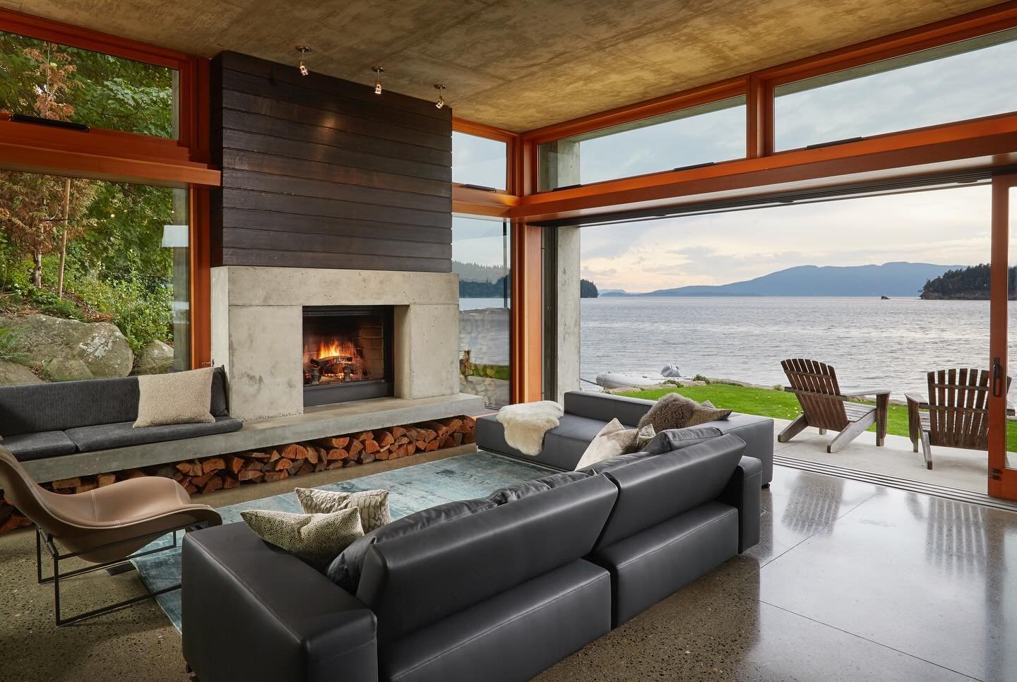 #MCT_BayHouse features a wood burning fireplace clad in Shou Sugi Ban charred timber siding, framing the view of Bellingham Bay through 40ft Lift &amp; Slide doors #MCTarch