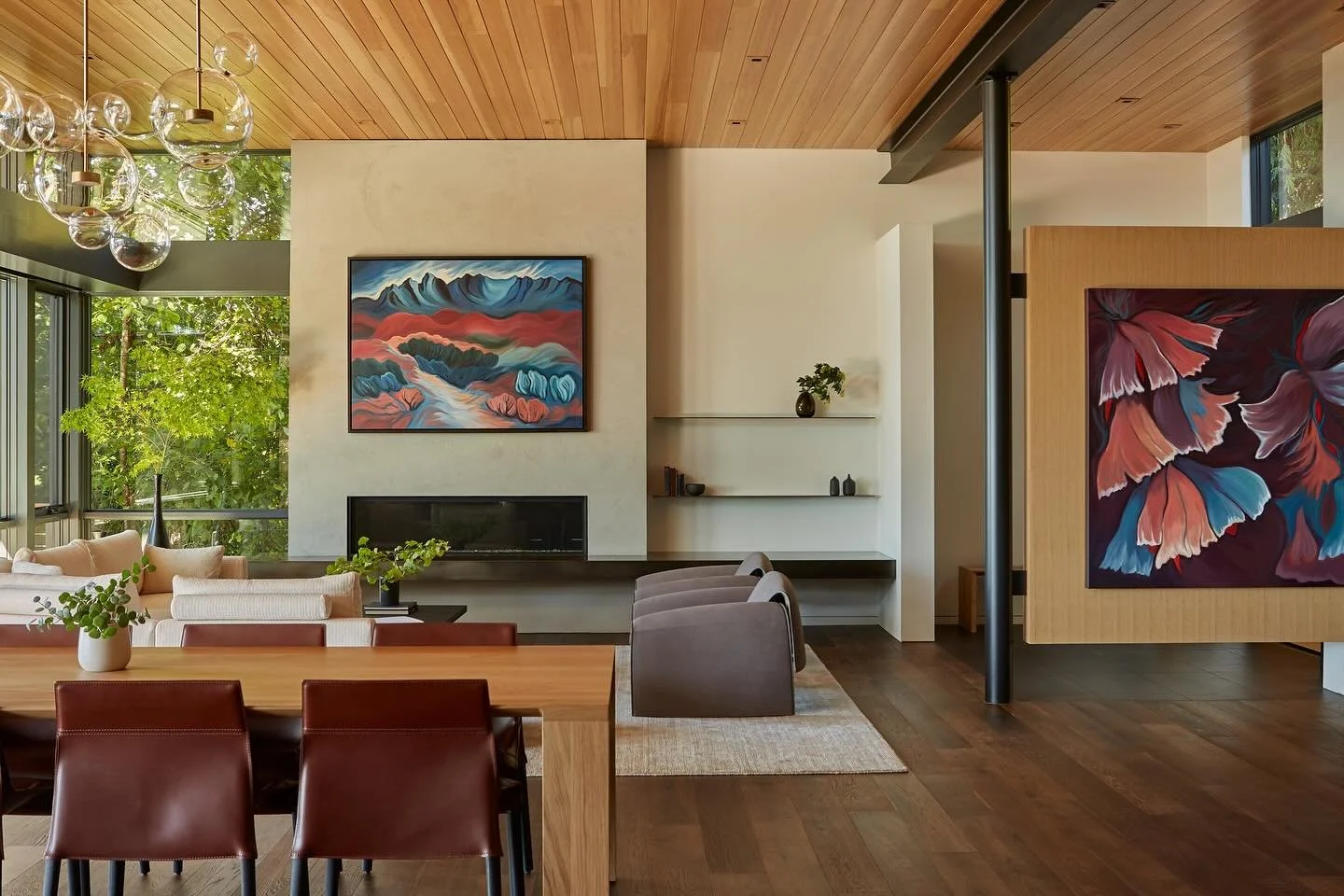 Designed as an open-concept gathering space, the great room at our #MCT_CorvusHouse frames picturesque views of Lake Washington through expansive floor-to-ceiling glazing, thoughtfully paired with vibrant custom artwork by @jillloganartisttodossantos