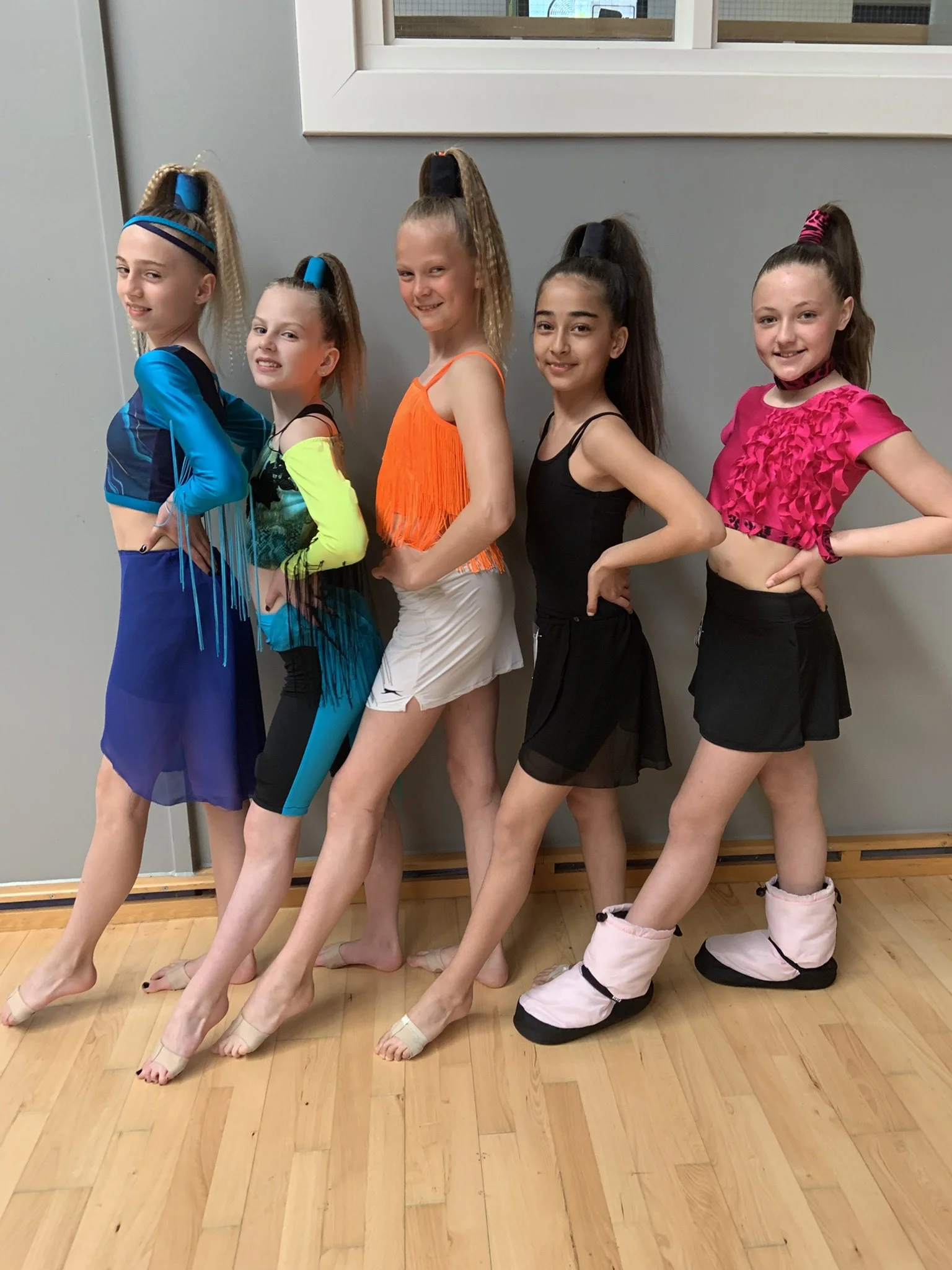 Fem dansere fra Dansefeber i Viby J i farverige konkurrencekostumer, studieportræt