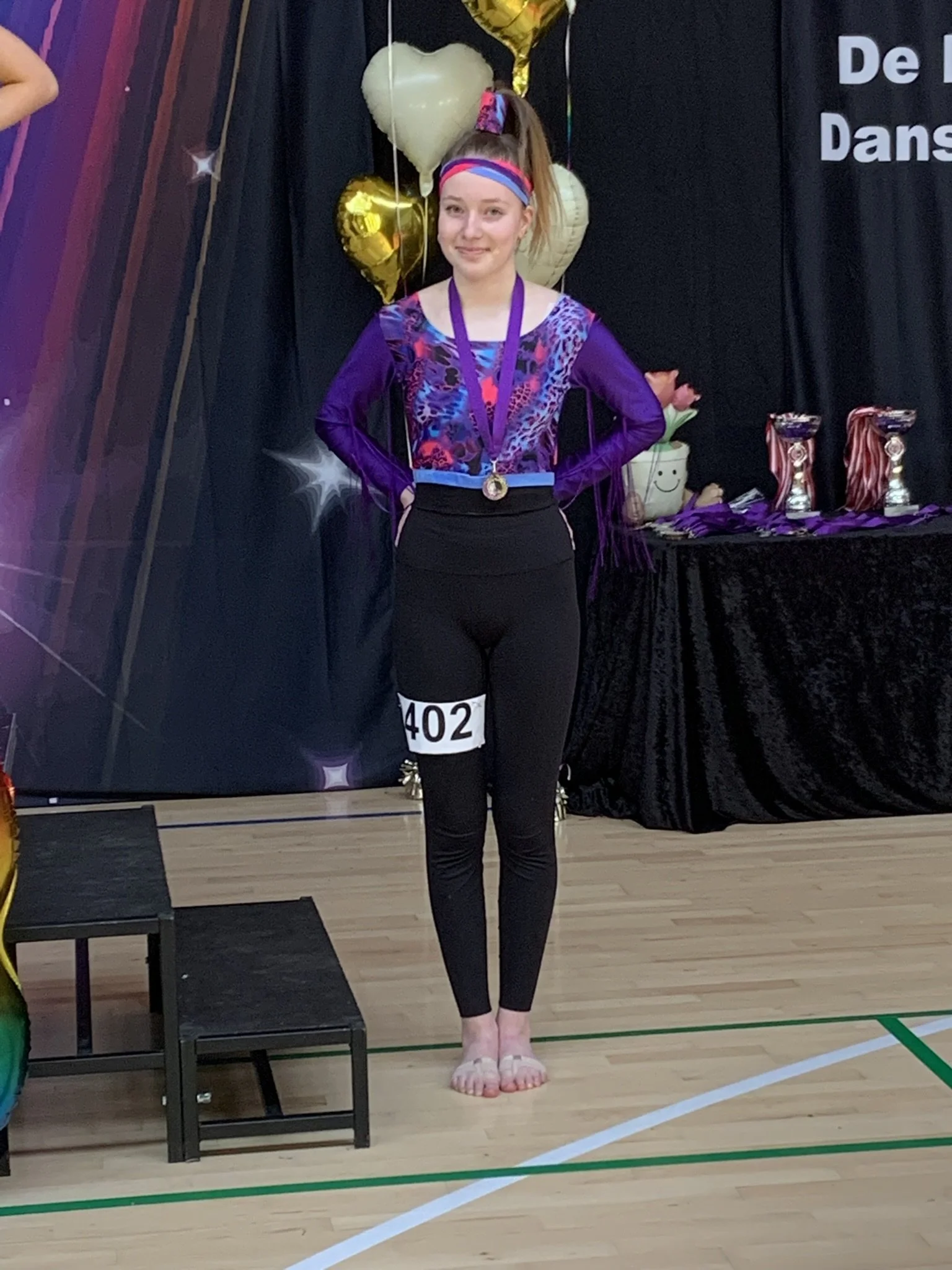 Discodanser fra Dansefeber i Aarhus Syd med medalje ved dansekonkurrence, i sort og lilla dragt