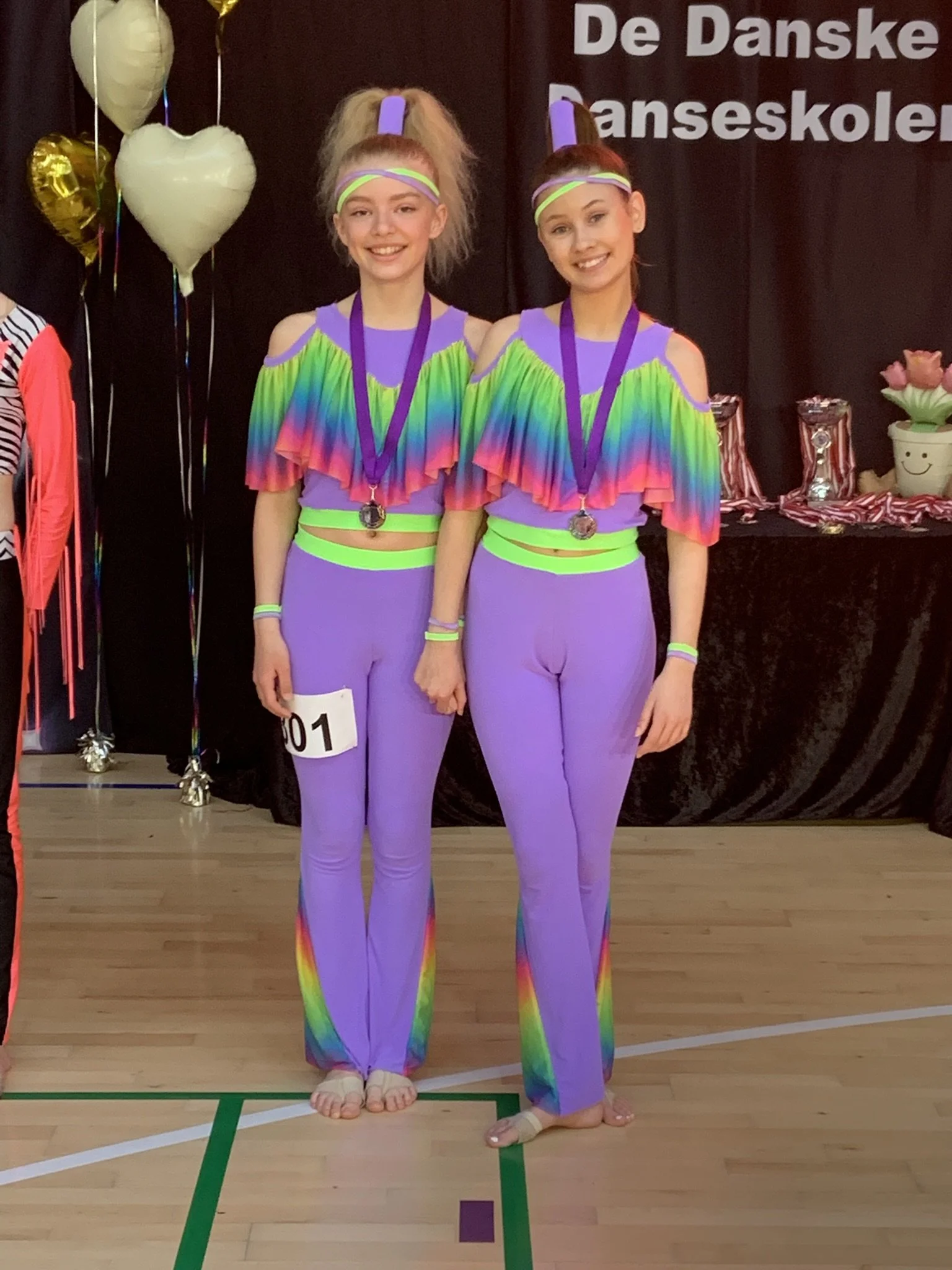 Discoduo fra Dansefeber i Viby J med medaljer ved dansekonkurrence, i lilla og regnbuefarvede dragter