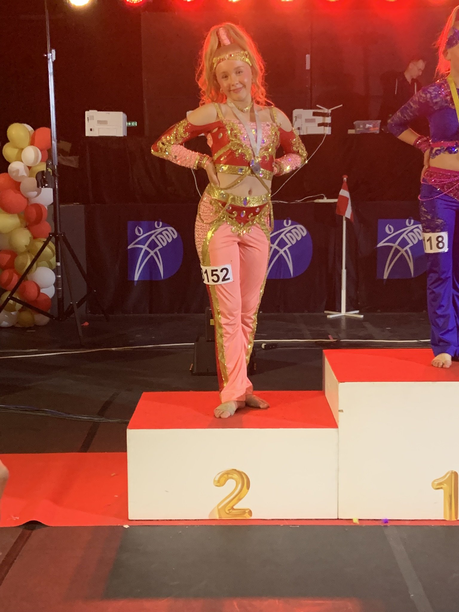 Danser fra Dansefeber i rød guld discodragt til disco solo ved Danmarksmesterskaberne 2026 i Forum Horsens – 2. plads