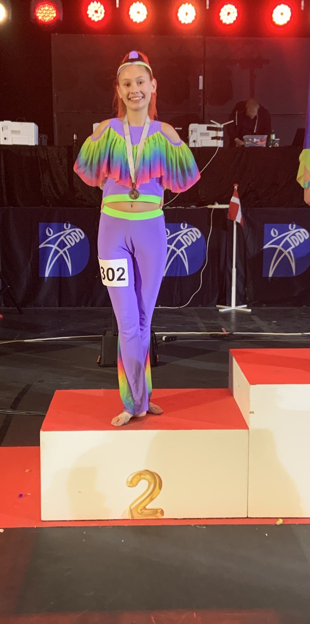 Danser fra Dansefeber i regnbue discodragt til disco solo ved Danmarksmesterskaberne 2026 i Forum Horsens – 2. plads