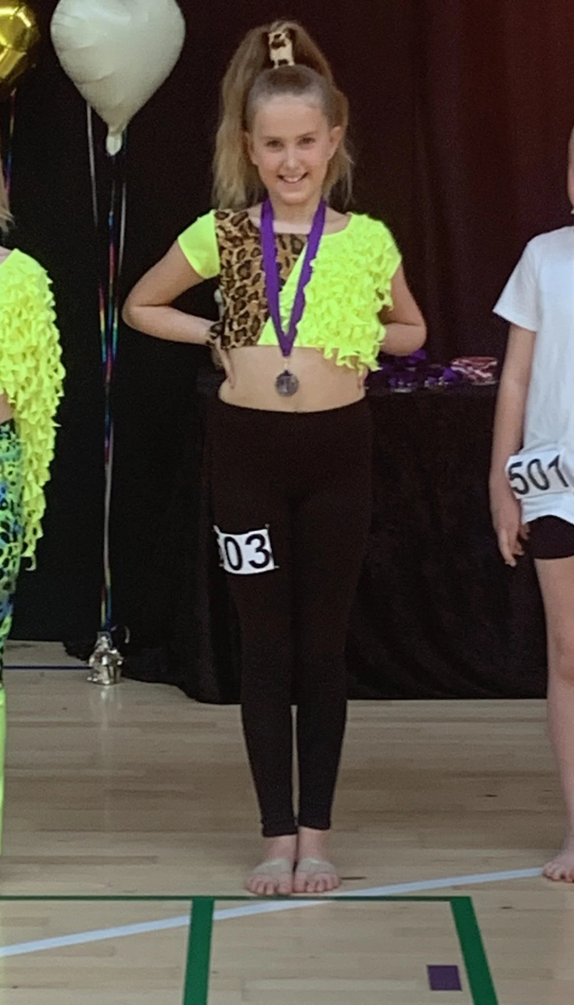 Discodanser fra Dansefeber i Viby J med medalje ved dansekonkurrence, i gul leopardmønstret dragt
