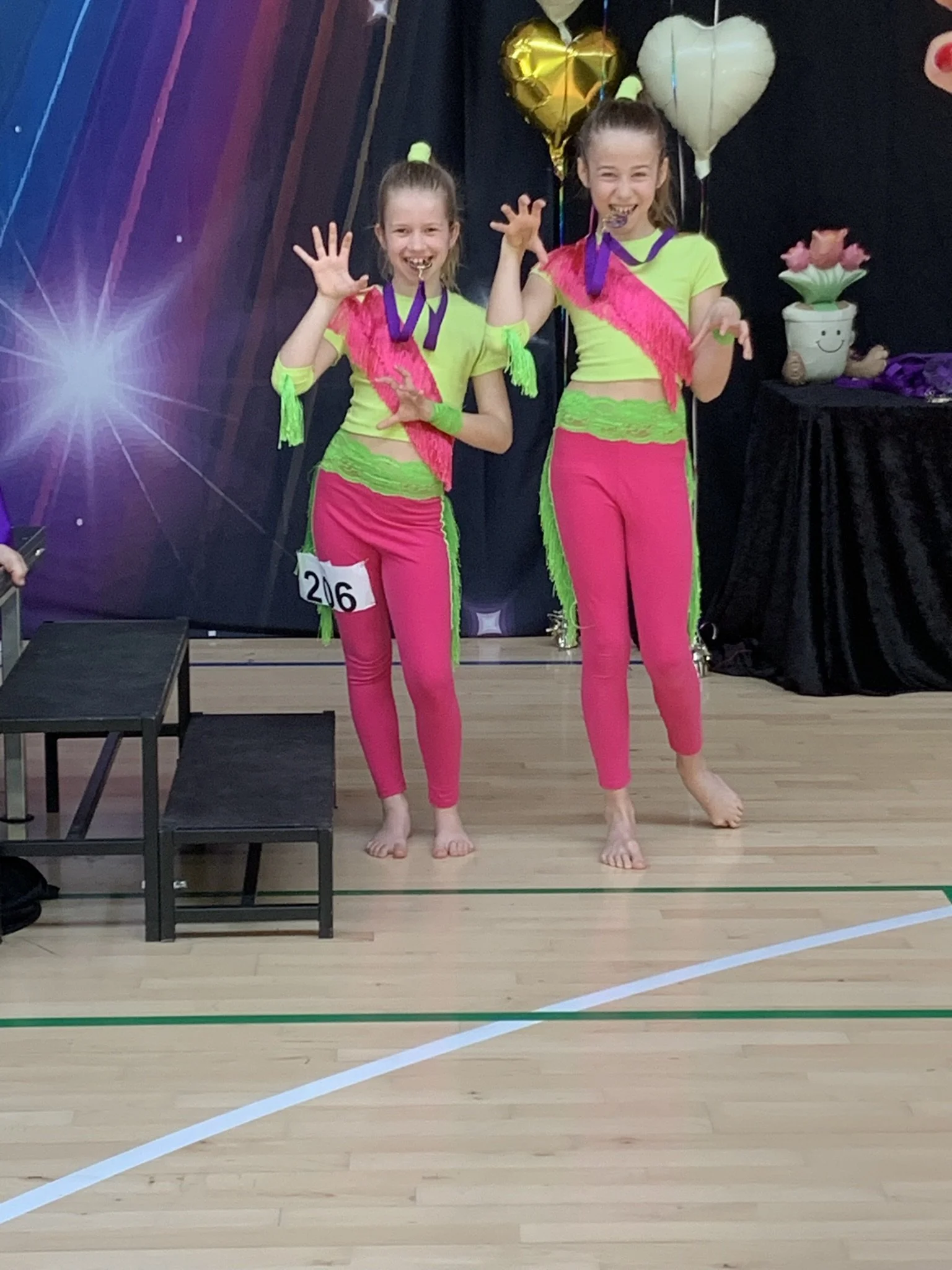 Discoduo fra Dansefeber i Viby J med medaljer ved dansekonkurrence, i gul og pink dragter