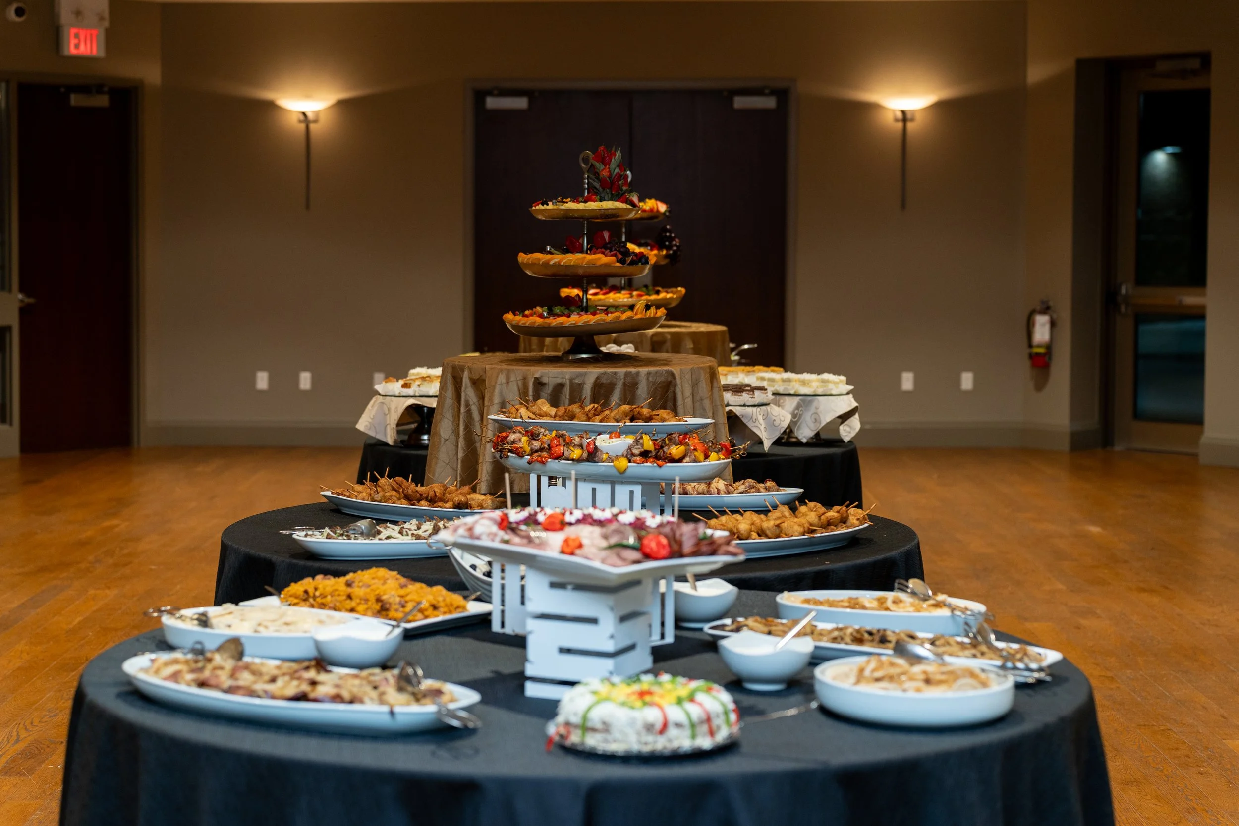 A buffet table with various dishes and desserts in a banquet hall.