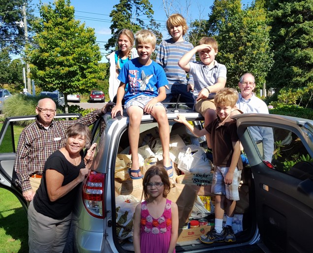 Kids and adults pose after helping load bags and bags of groceries destined for the Redding food pantry.