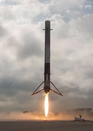 SpaceX booster lands for re-use after launching a Falcon 9 rocket.