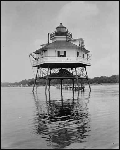 This early photo of the lighthouse shows a long pier stretching from the beach (photo from the Mariners Museum)