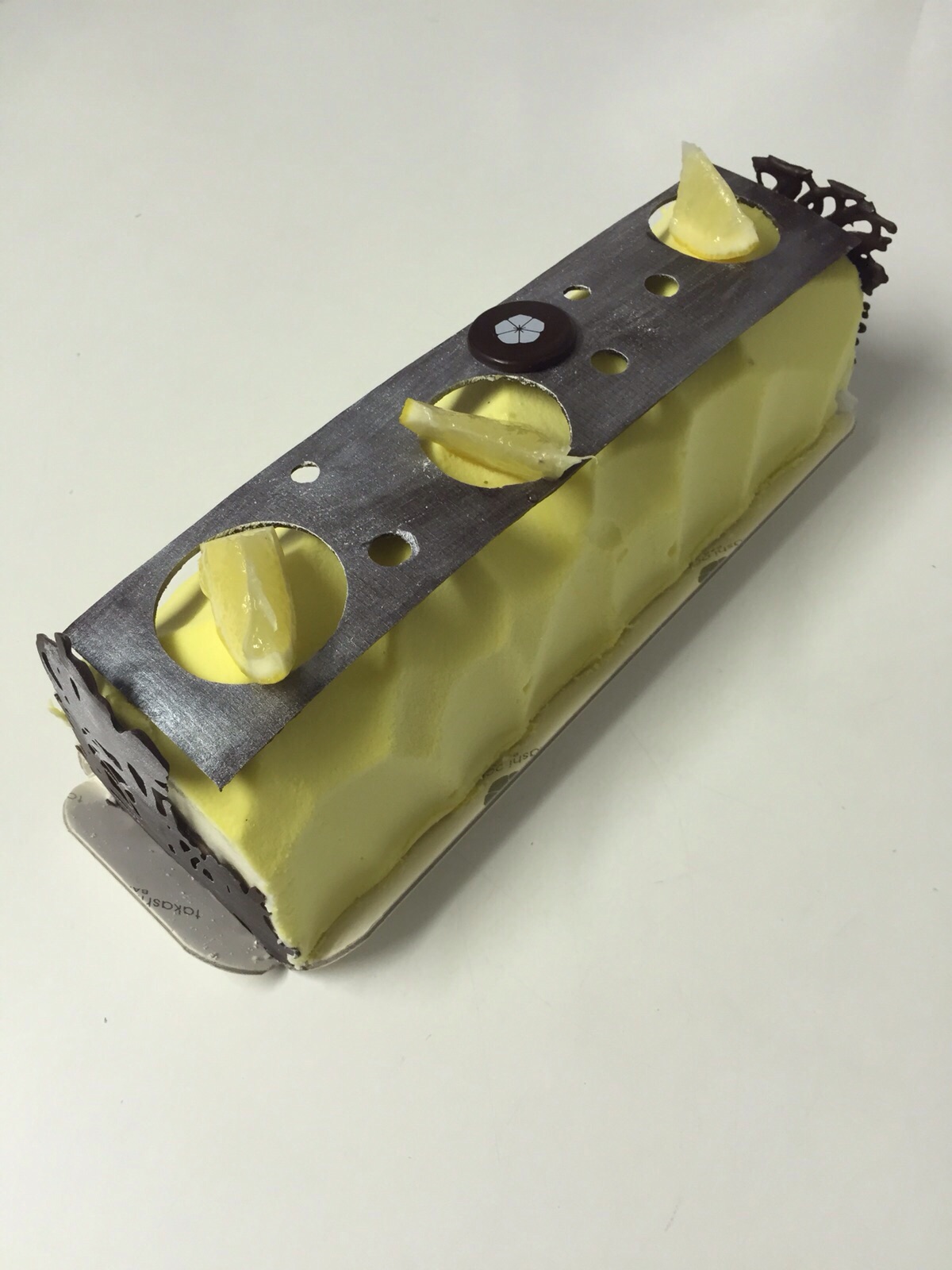 Mousse de xocolata blanca i yuzu amb interior de gel de gengibre, cheese cake de xocolata i sable (galeta) reconstruït d'avellana. 