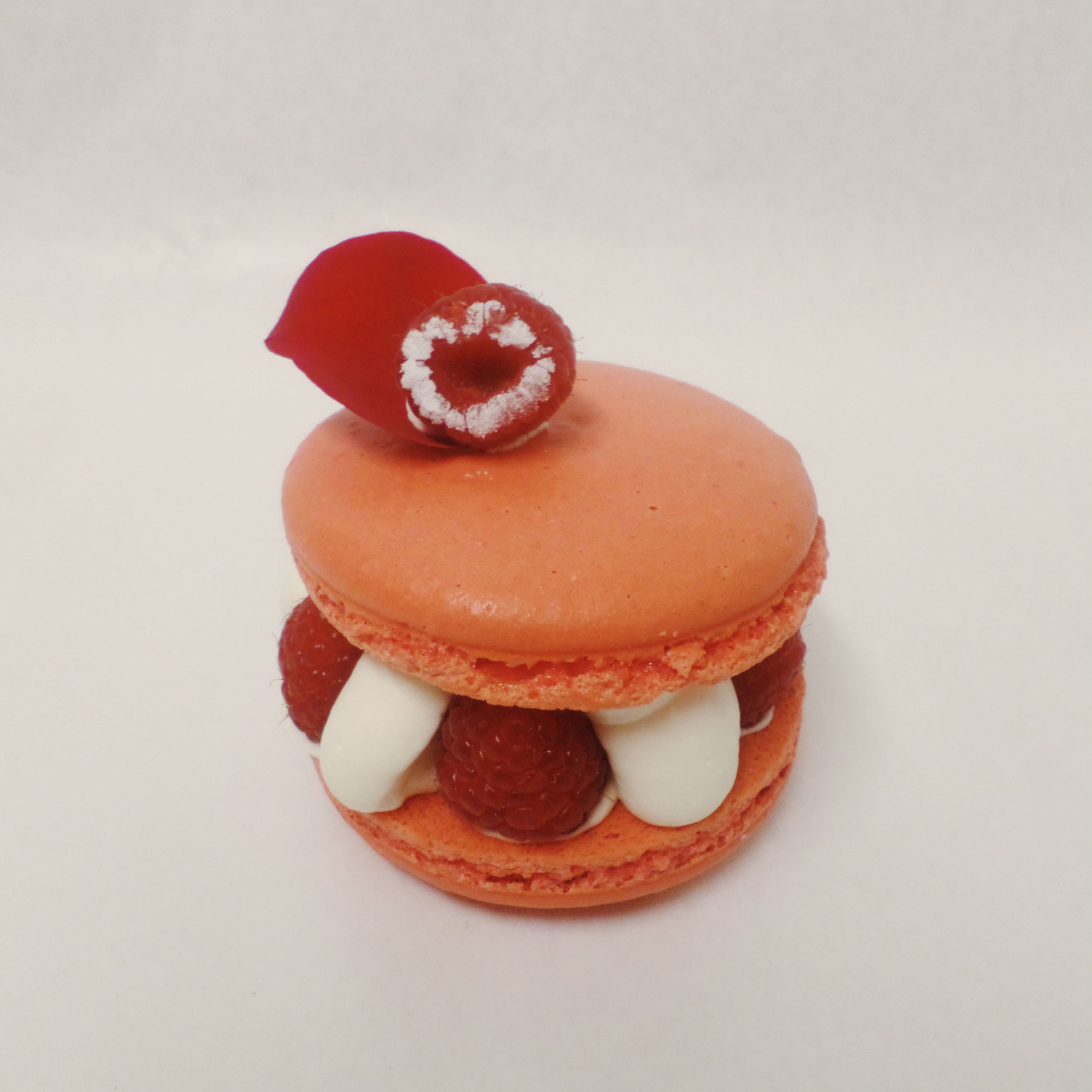 Macaron con ganache de chocolate blanco y rosa, coulis de frambuesa y frambuesas naturales