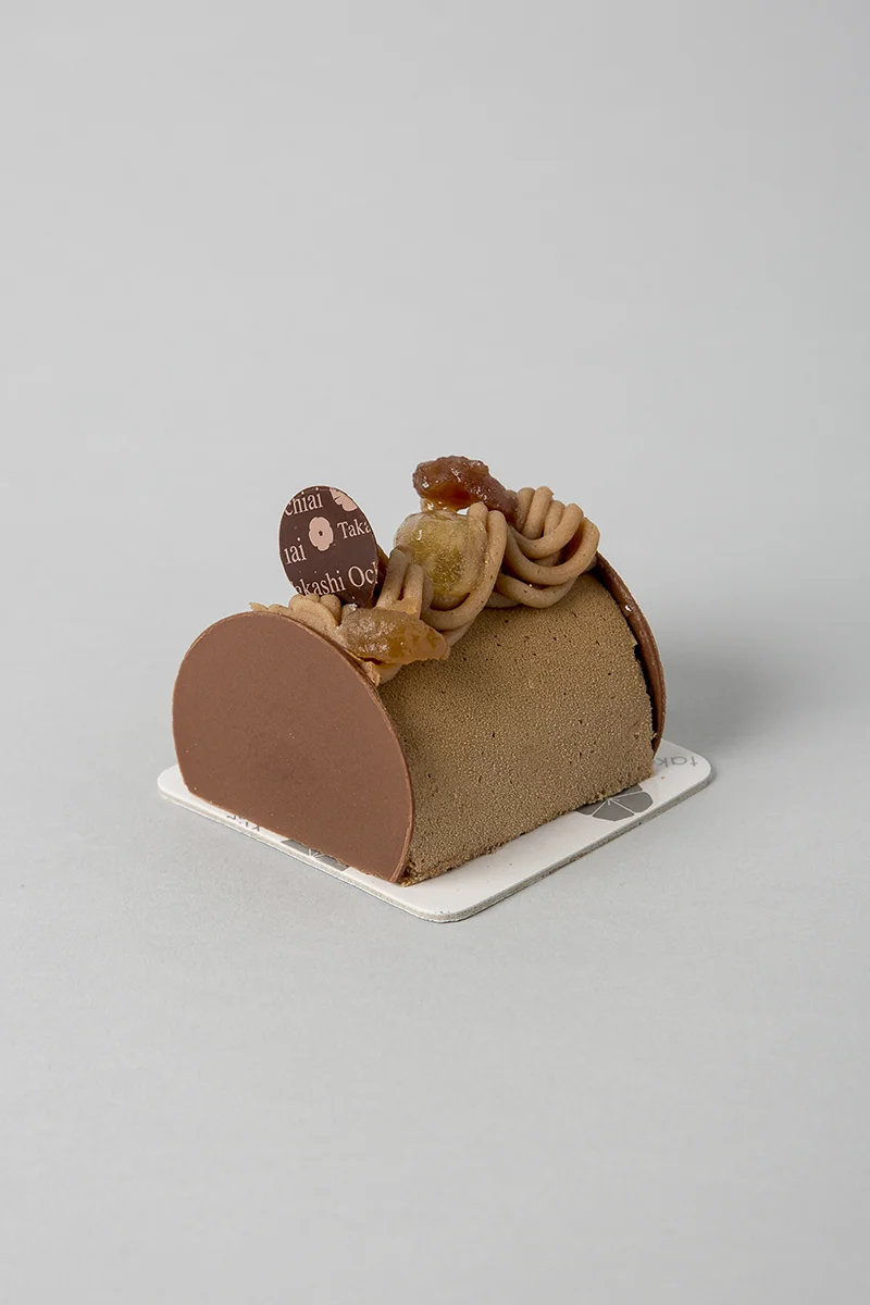 Tardor. Pa de pessic i cruixent d'avellana, crema de yuzu, mousse de xocolata amb llet Jivara 40%, crema de castanya i bocins de castanya i avellana a l'interior. 