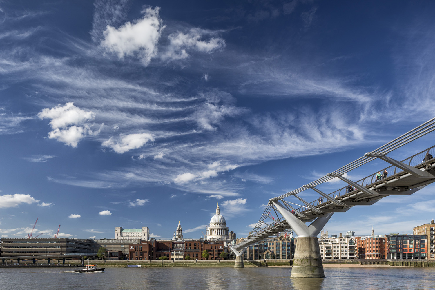 Elegant steel suspension footbridge crossing the Thames from the Tate Modern to St Paul's Cathedral.