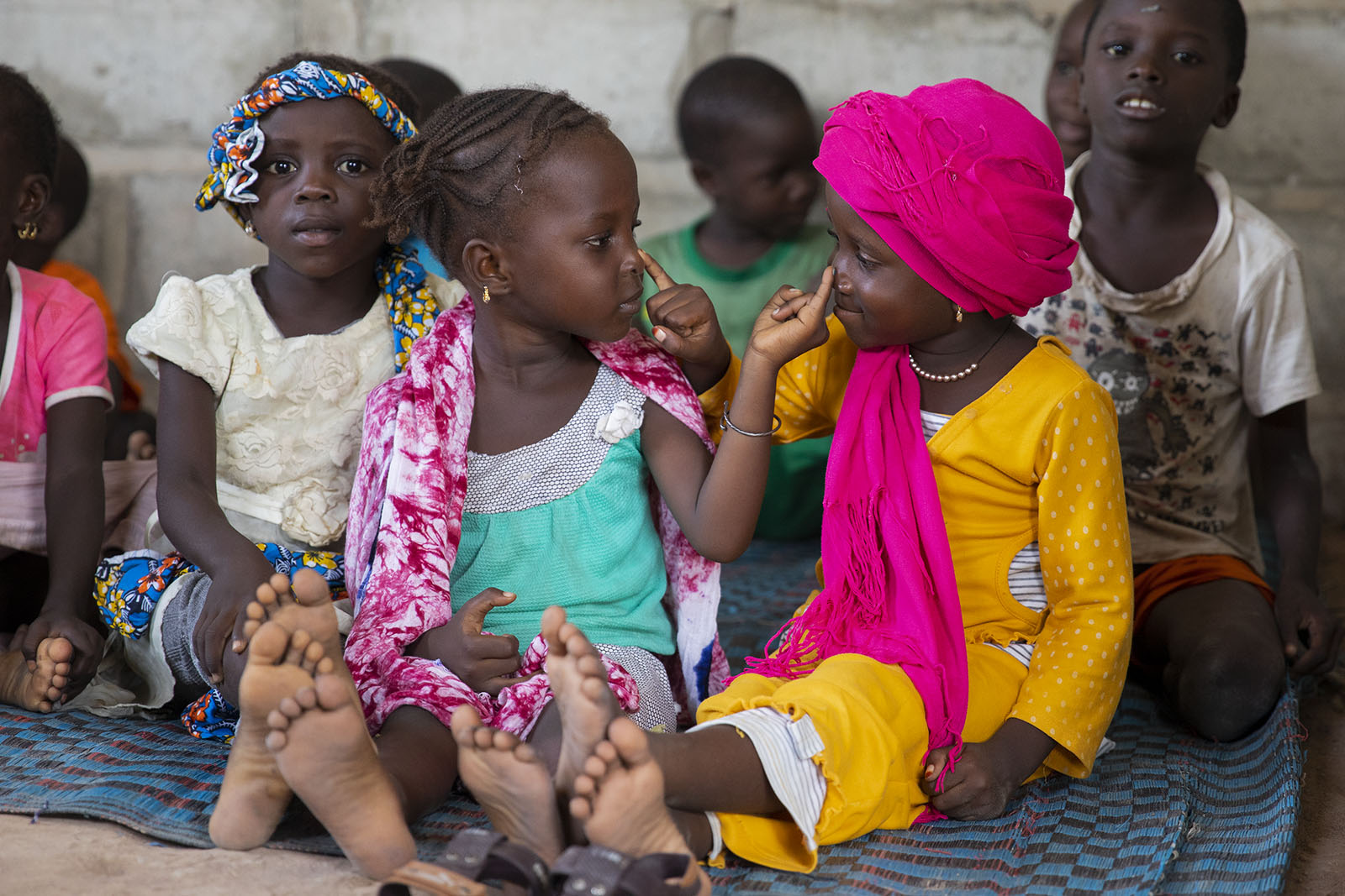  Hothia Balde, left, and Ansata Diao get a little distracted while being taught prayers from The Quran on March 09, 2019 in Kolda, Senegal. While the women are watching Gangaa, Mamadou (not pictured) takes this time to look after the children. 