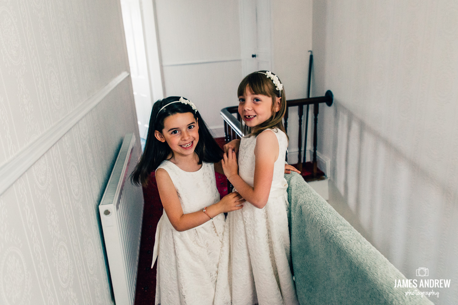 bridesmaid and flower girl playing on stairs