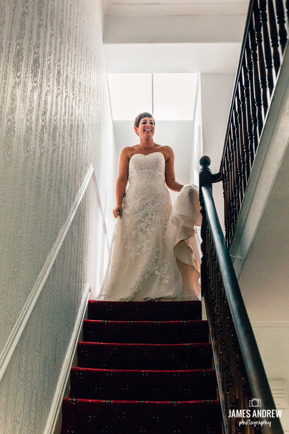 bride in wedding dress at the top of staircase bright light