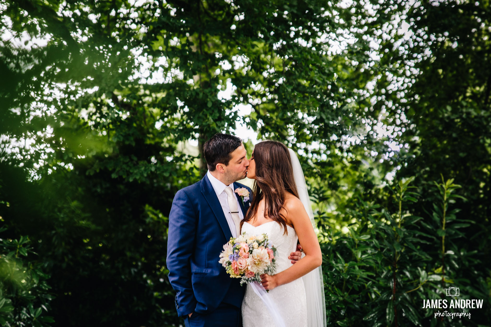 Bride And Groom Kissing In Green Woodland outdoors
