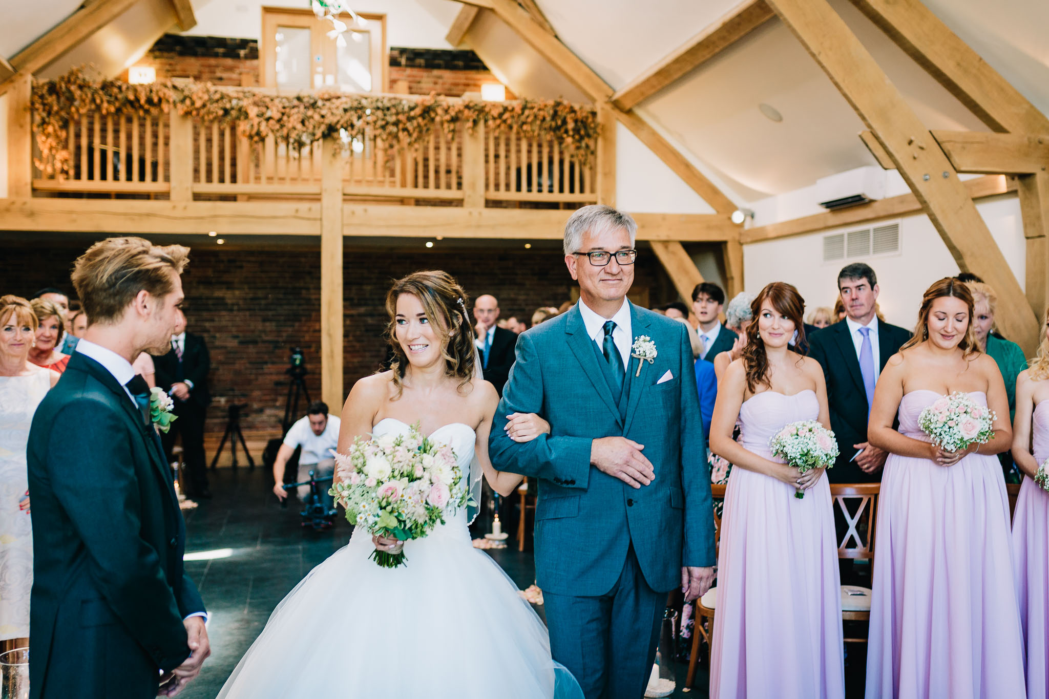 BRIDE AND DAD LOOKING AT GROOM IN CHURCH
