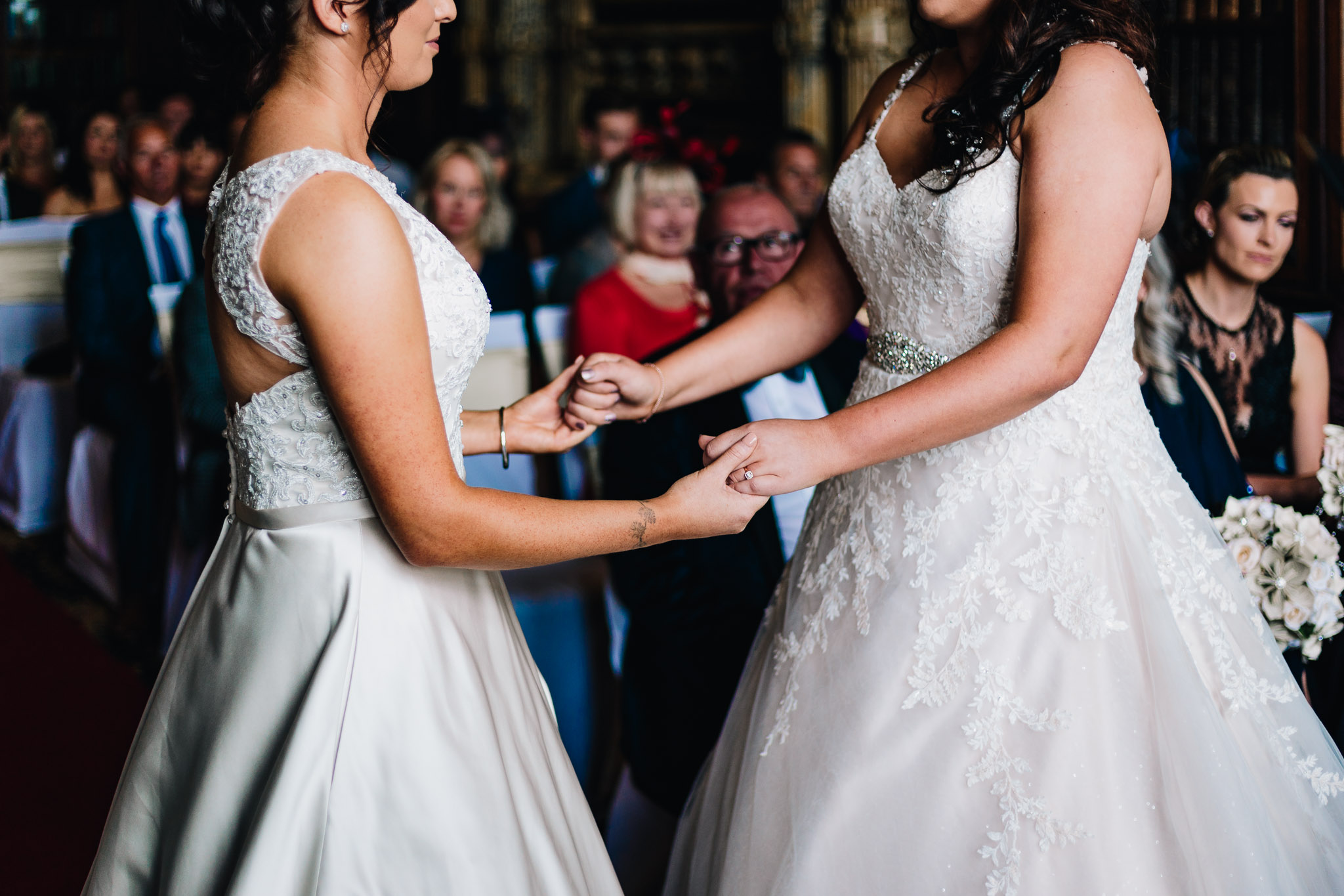 BRIDES HOLDING HANDS AT WEDDING CEREMONY