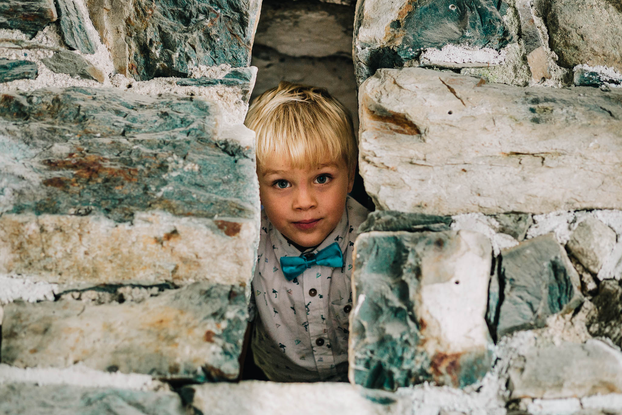 CHEEKY BLONDE BOY PEERING THROUGH GAP IN BARN WALL