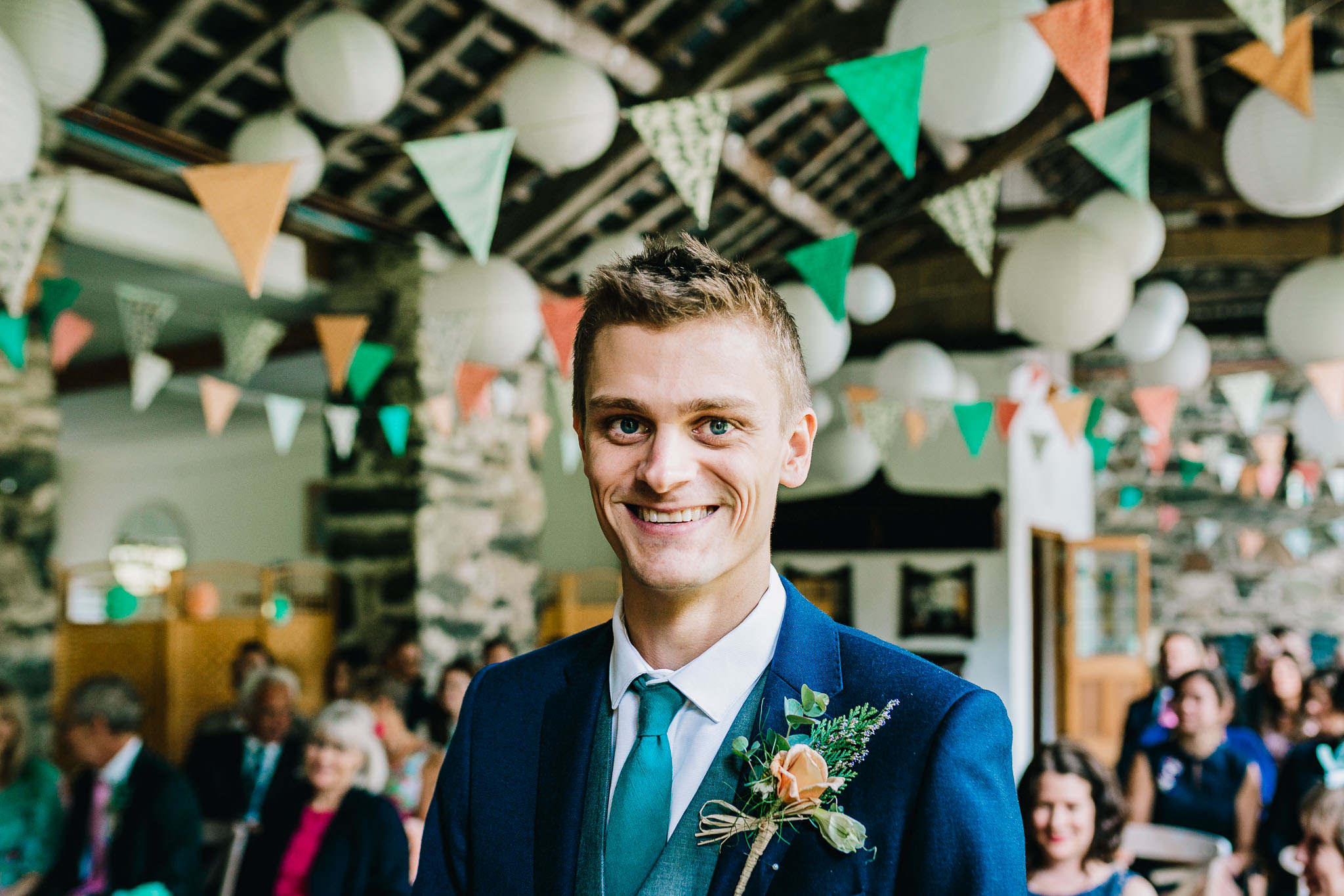 GROOM SMILING WHILE STOOD IN THE ISLE WAITING FOR BRIDE TO ARRIVE