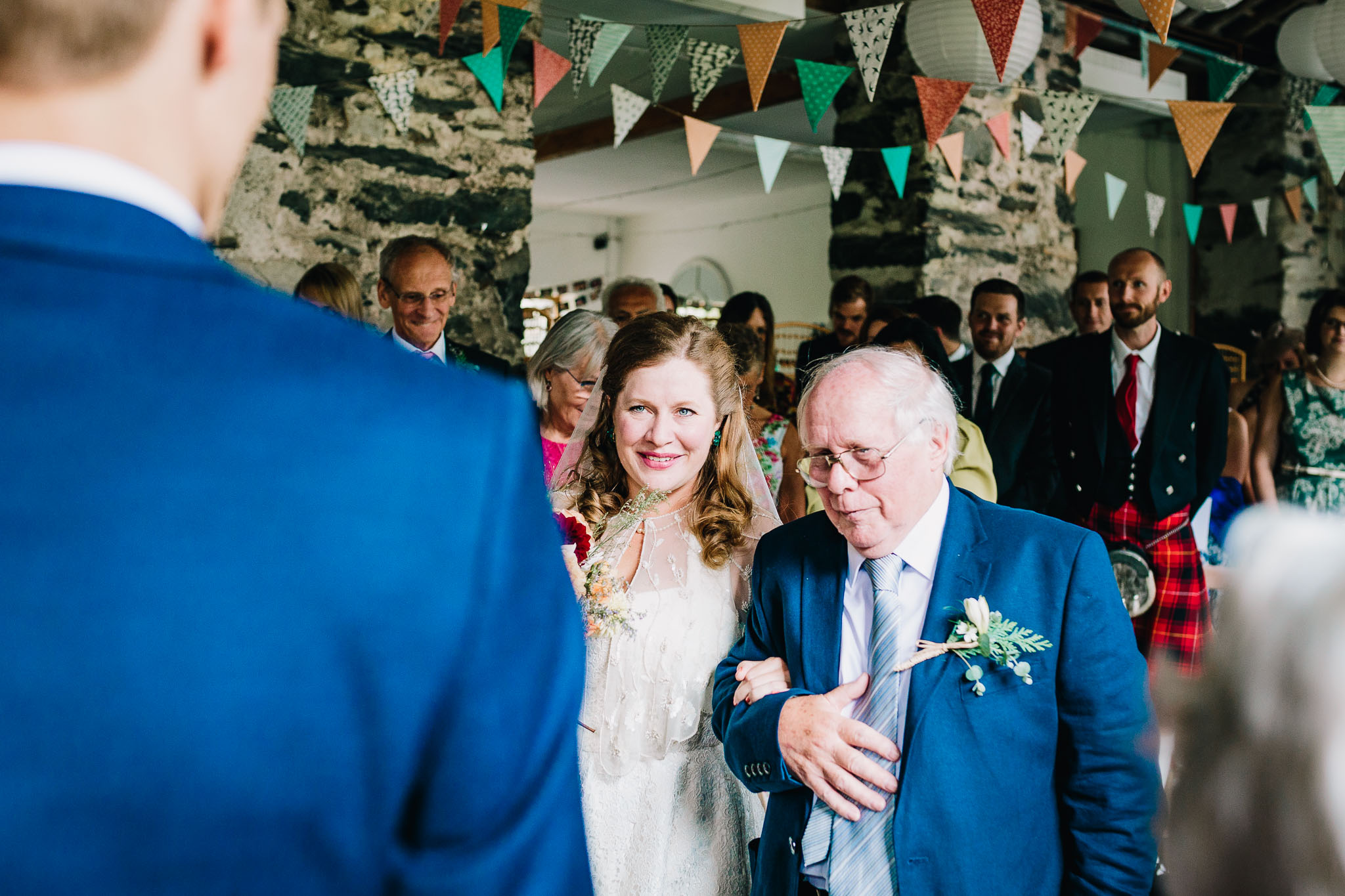 BRIDE AND FATHER WALKING DOWN THE ISLE IN TO STONE BARN WALES