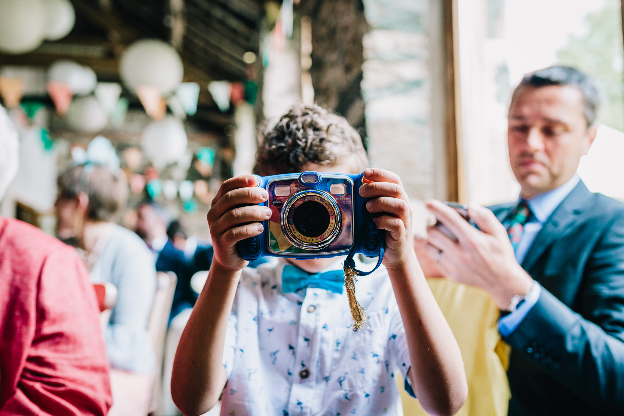 KID TAKING A CANDID PICTURE WITH TOY CAMERA