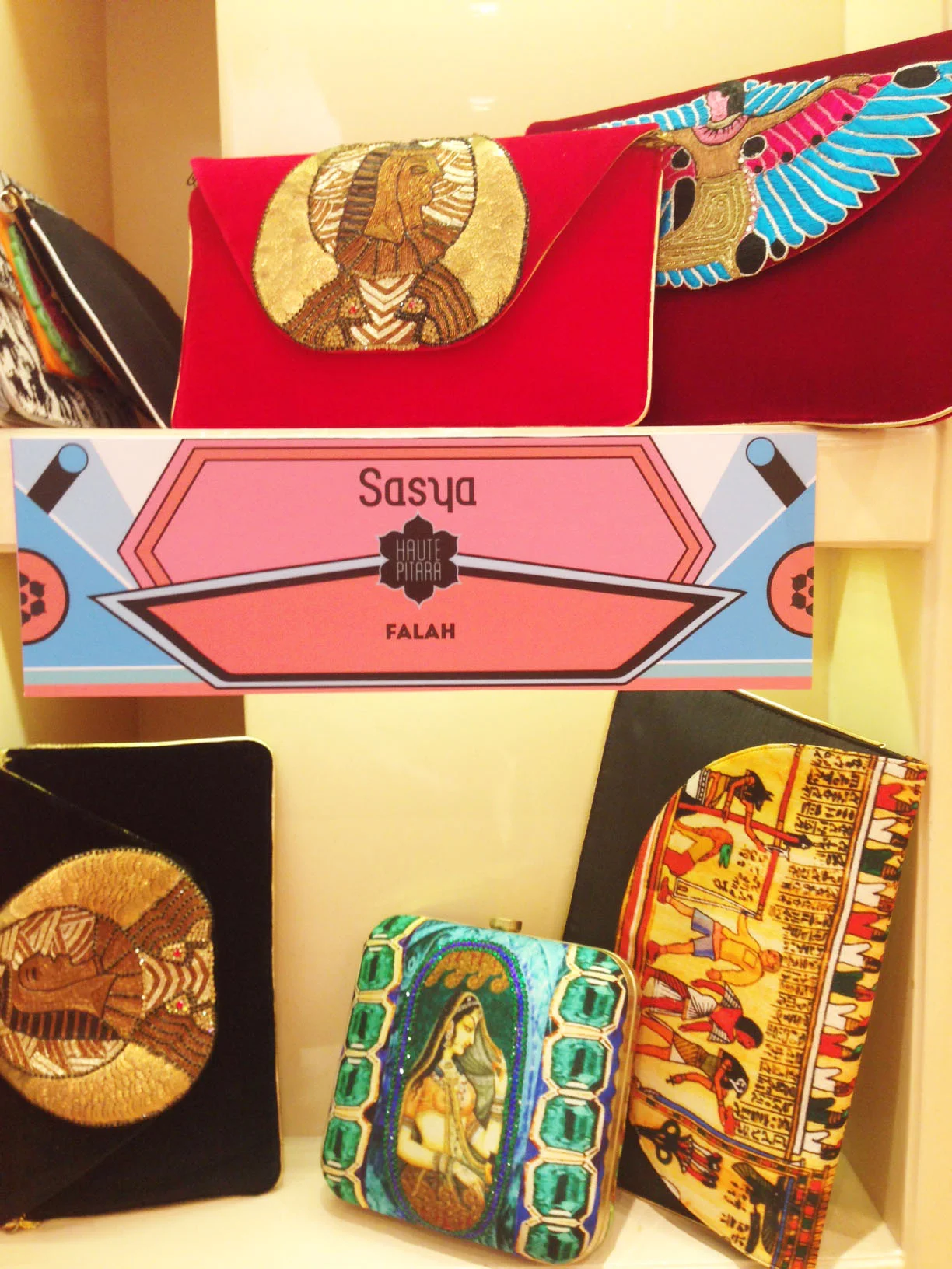 Various embroidered handbags with Egyptian and African motifs on display.