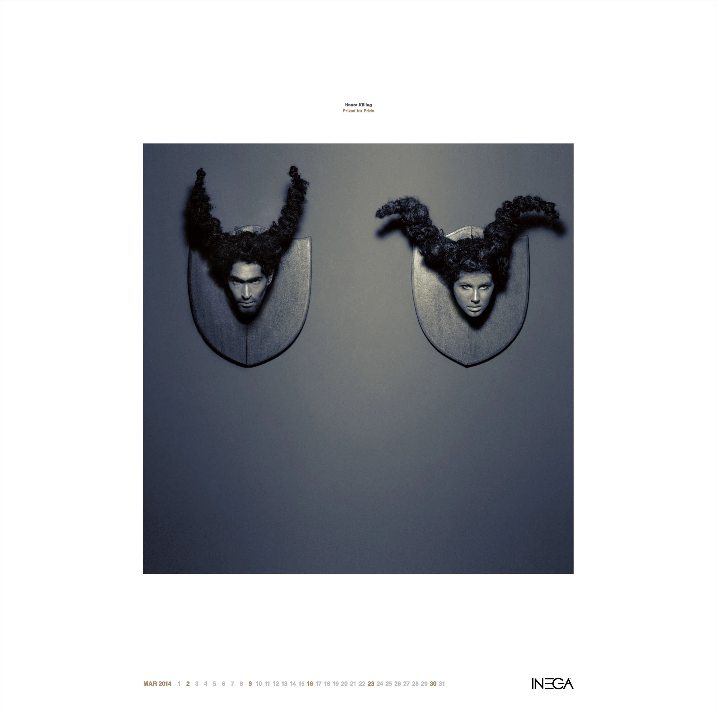 Two mounted wall sculptures resembling human heads with elaborate curly hair, positioned side by side against a gray background, part of a calendar page for March 2014, with the title 'Honor Killing' and the subtitle 'Praised for Pride' at the top.