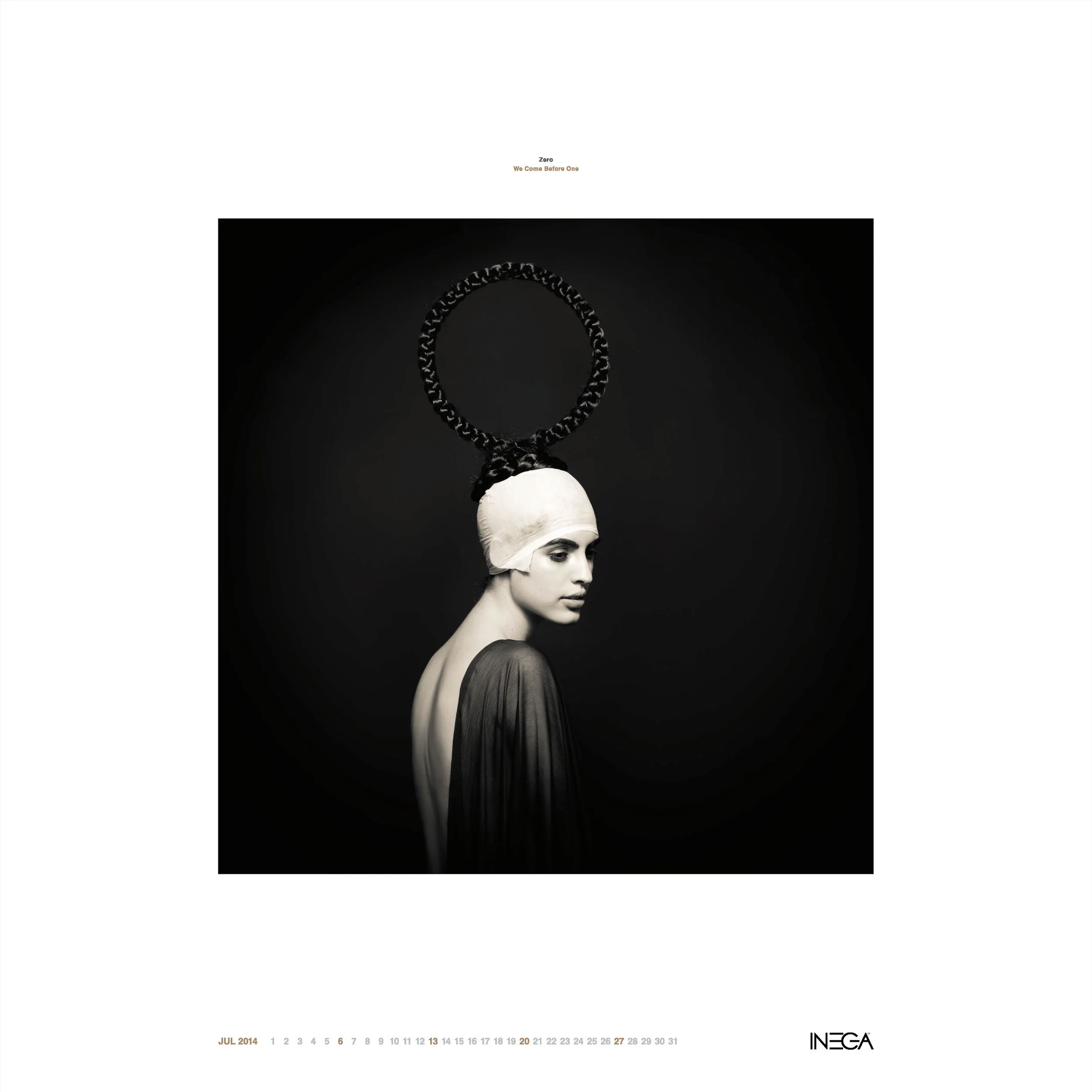 A black and white portrait of a woman with a stylized headpiece resembling a circular chain, wearing a dark flowing garment, against a dark background.